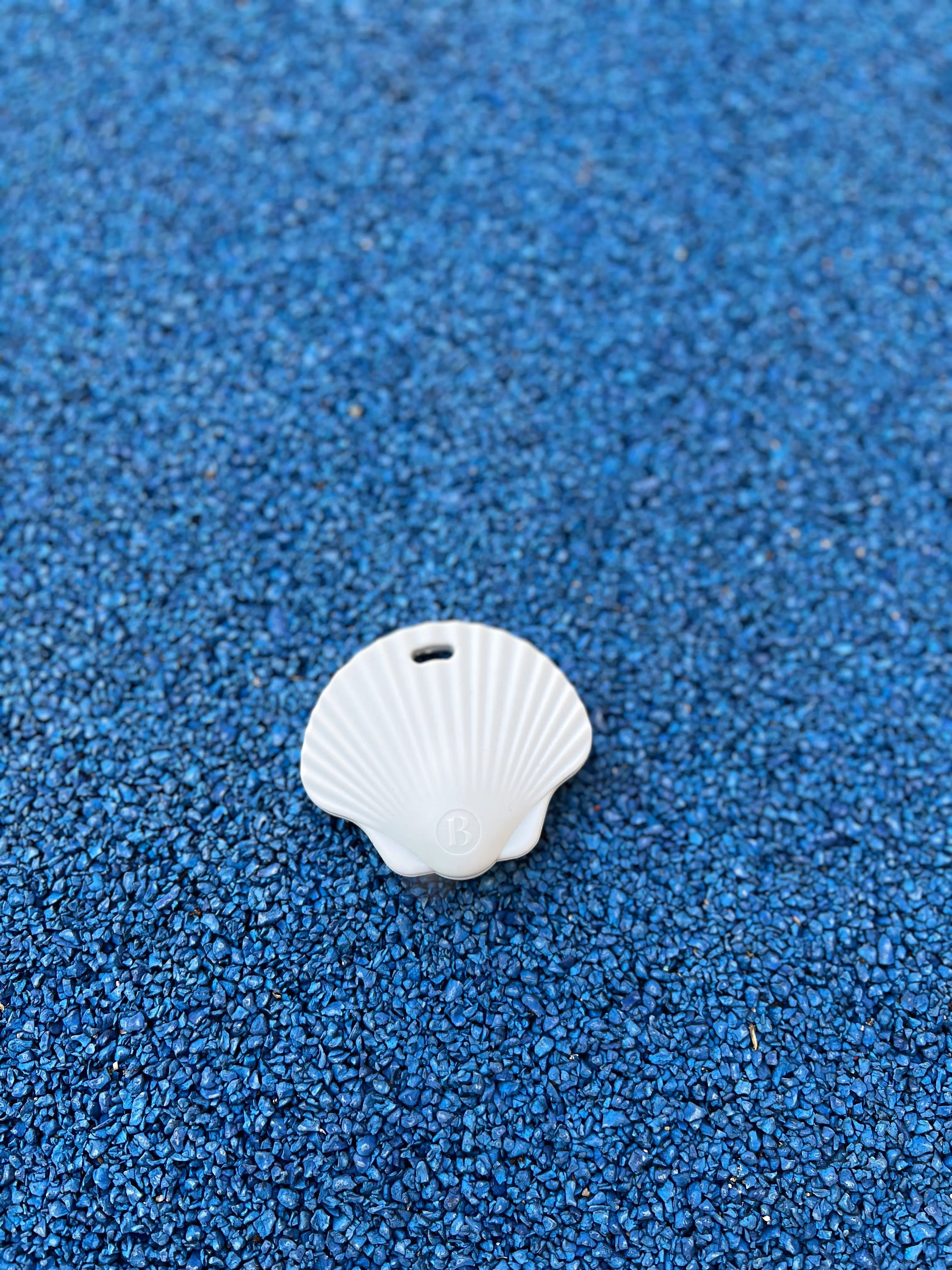 Anneau de dentition Shell Bleu Ciel sur un fond vibrant, mettant en avant son design adorable et ludique de coquillage, par Bim bam Bloom.
