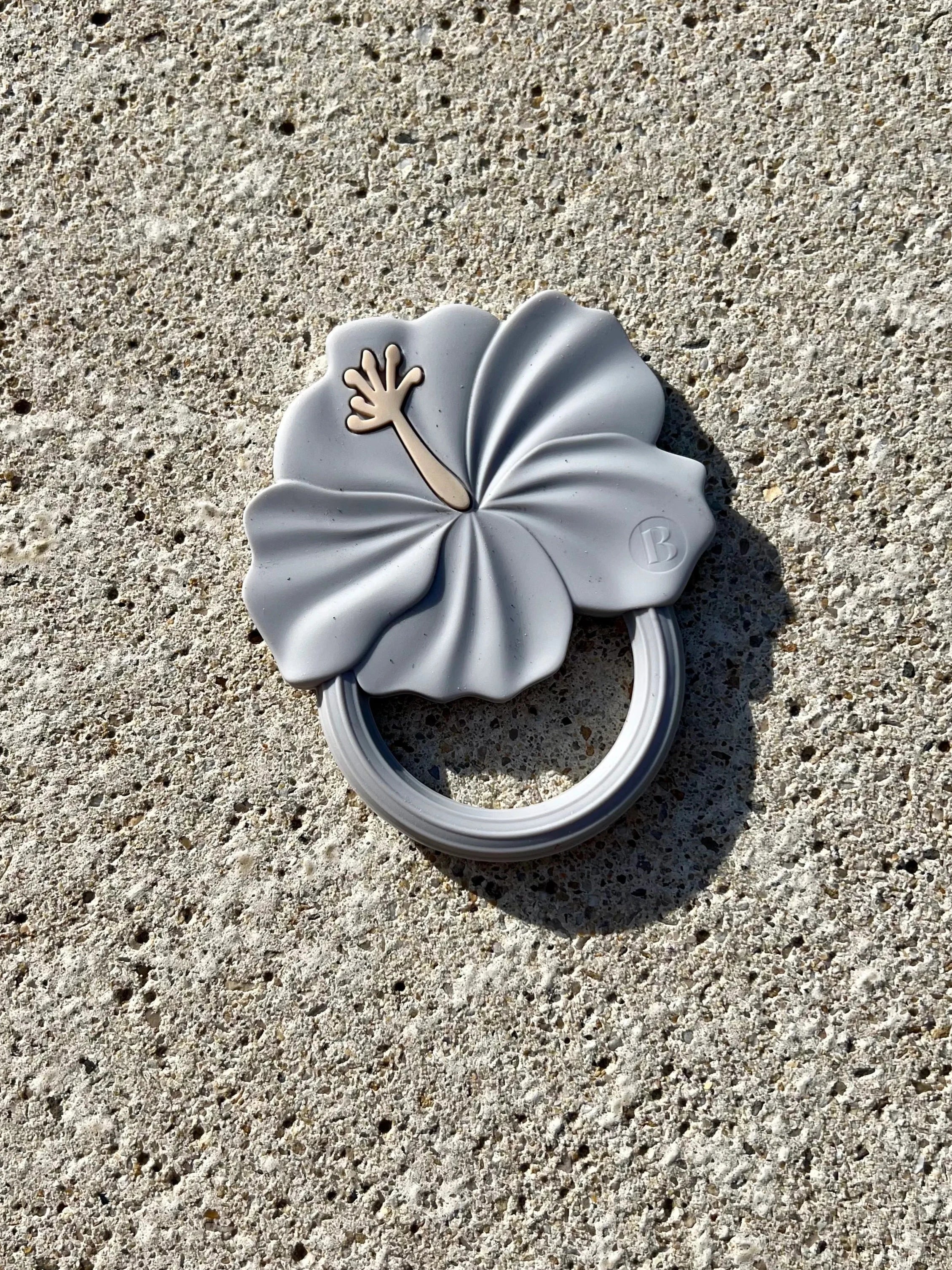 Anneau de dentition Flower Power en Bleu Ciel, conçu pour stimuler les sens et soulager les gencives de bébé pendant la poussée dentaire. Son design de fleur d'hibiscus est adorable.