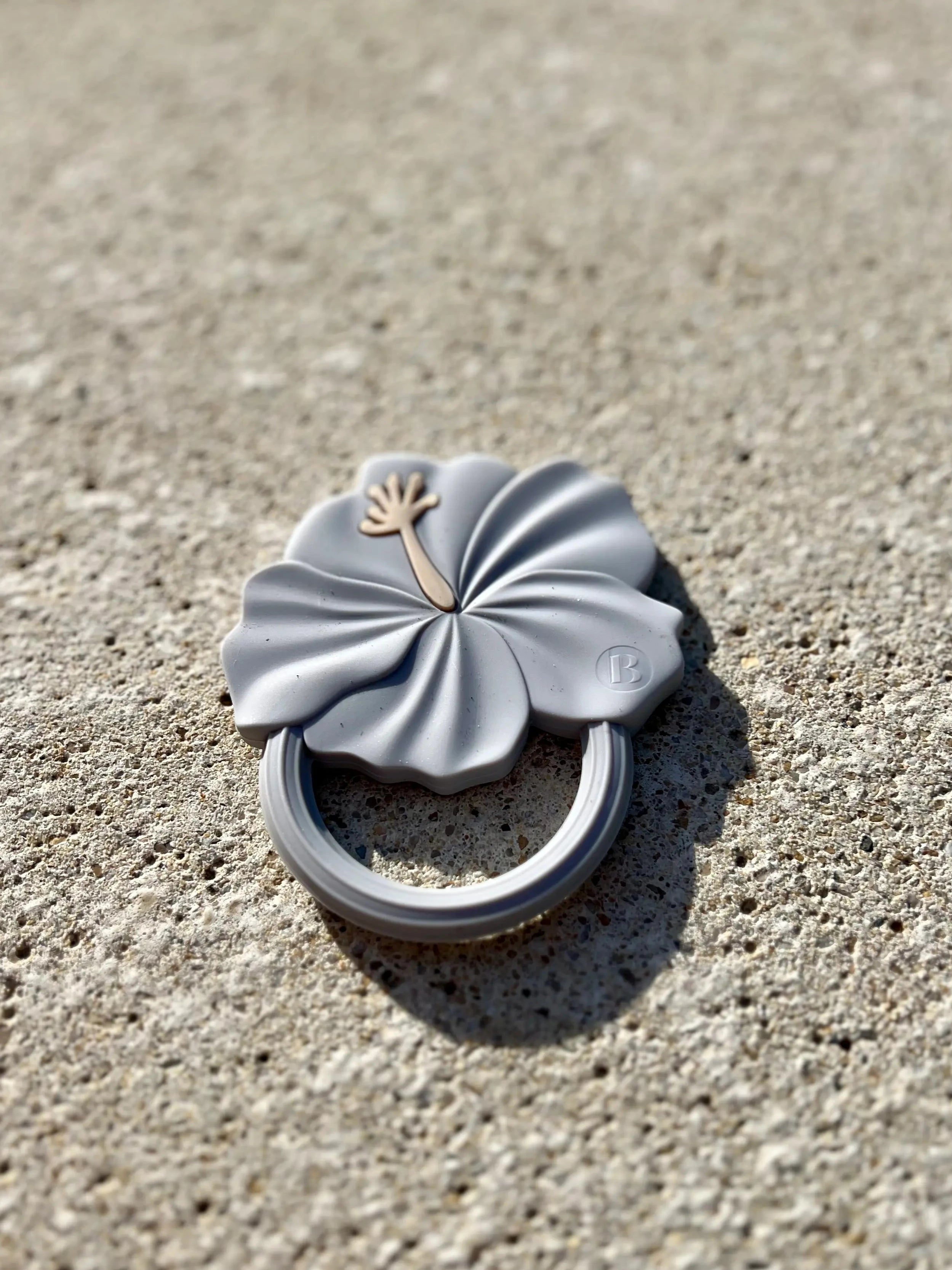 Anneau de dentition Flower Power en Bleu Ciel, conçu pour stimuler les sens et soulager les gencives de bébé pendant la poussée dentaire. Son design de fleur d'hibiscus est adorable.