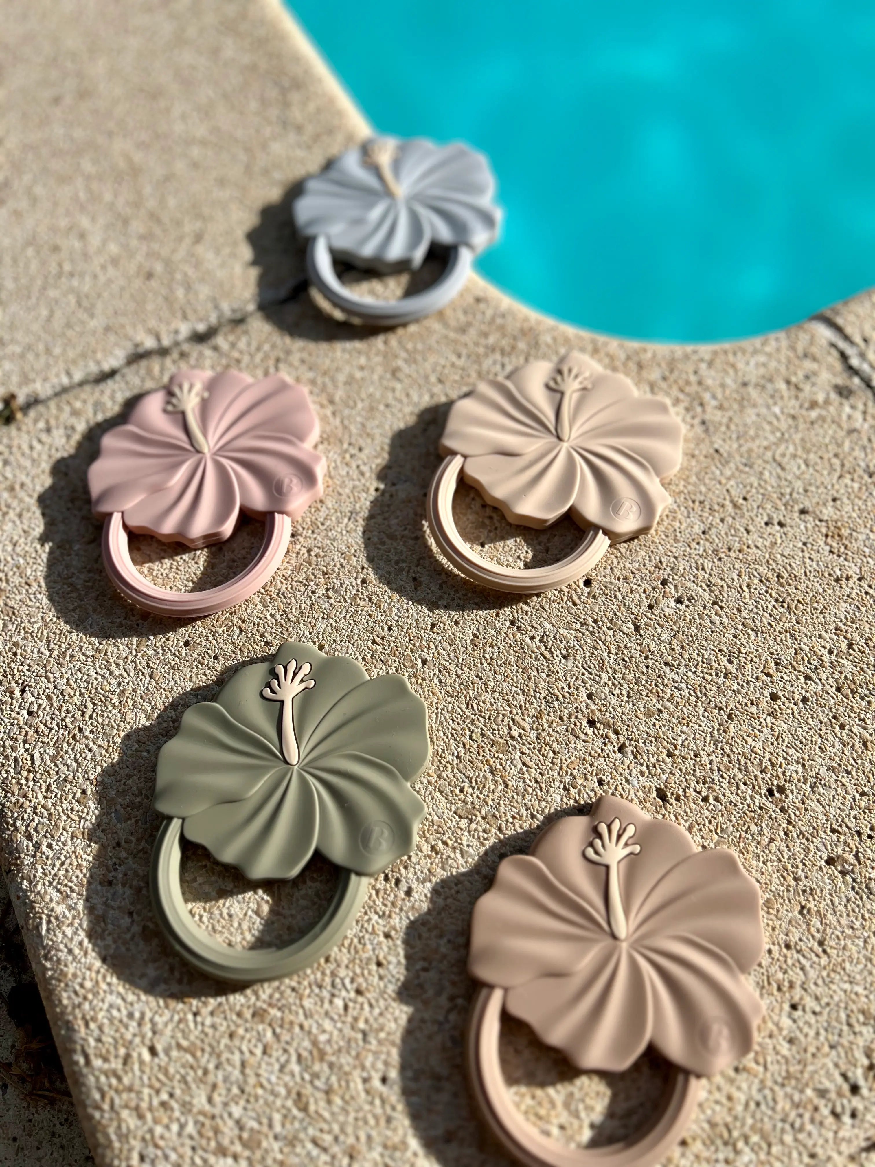 Nos 5 couleurs d'anneaux de dentition Flower Power au design de fleur d'hibiscus. Jouet de dentition doux et sûr pour le confort de votre bébé.