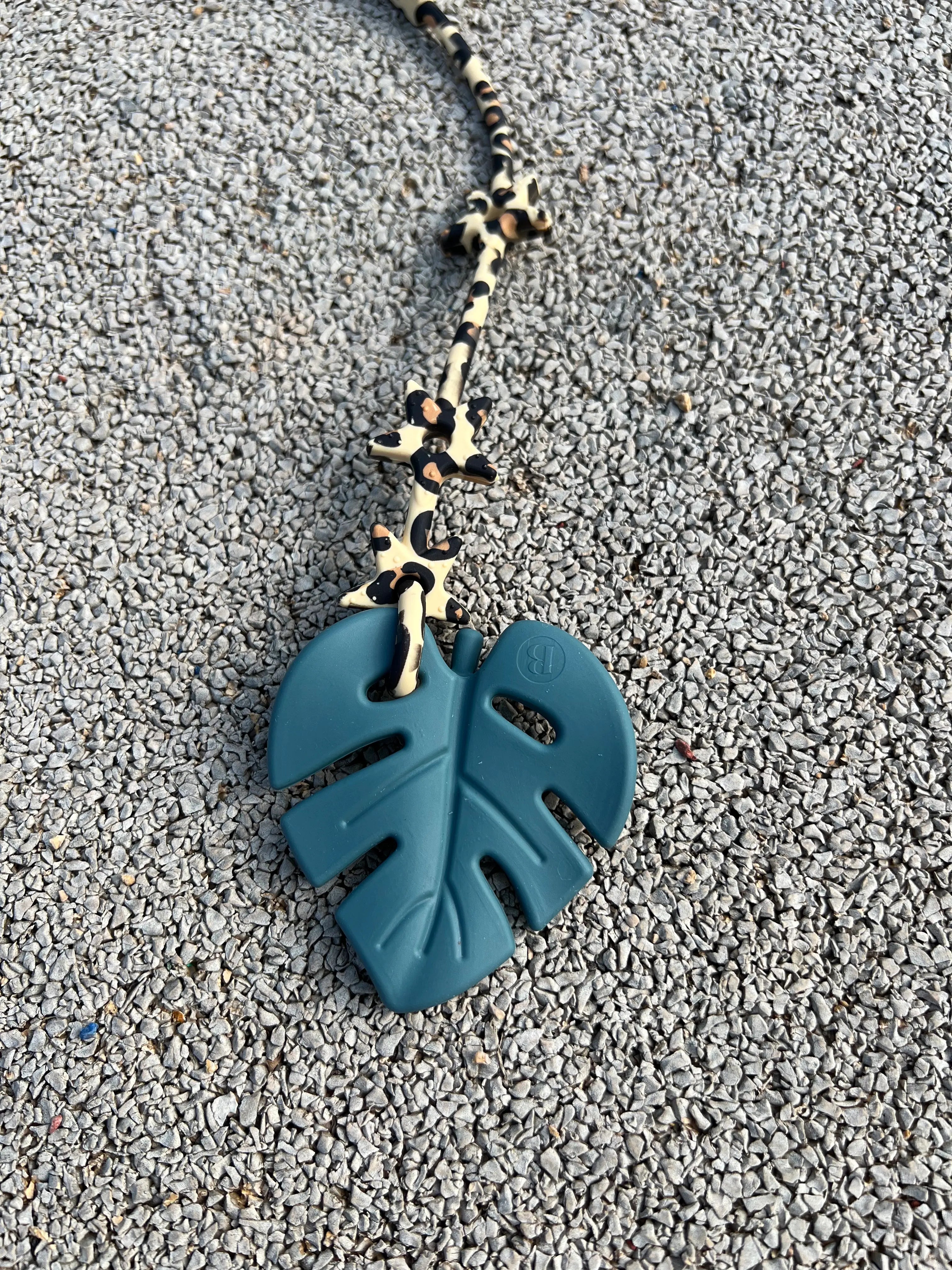 Anneau de dentition Leaf en Vert Tropicale, au design de feuille inspiré de la nature, pour stimuler les sens de bébé pendant la phase de dentition. Notre jouet de dentition est attaché avec l'attache doudou Lovie Link.