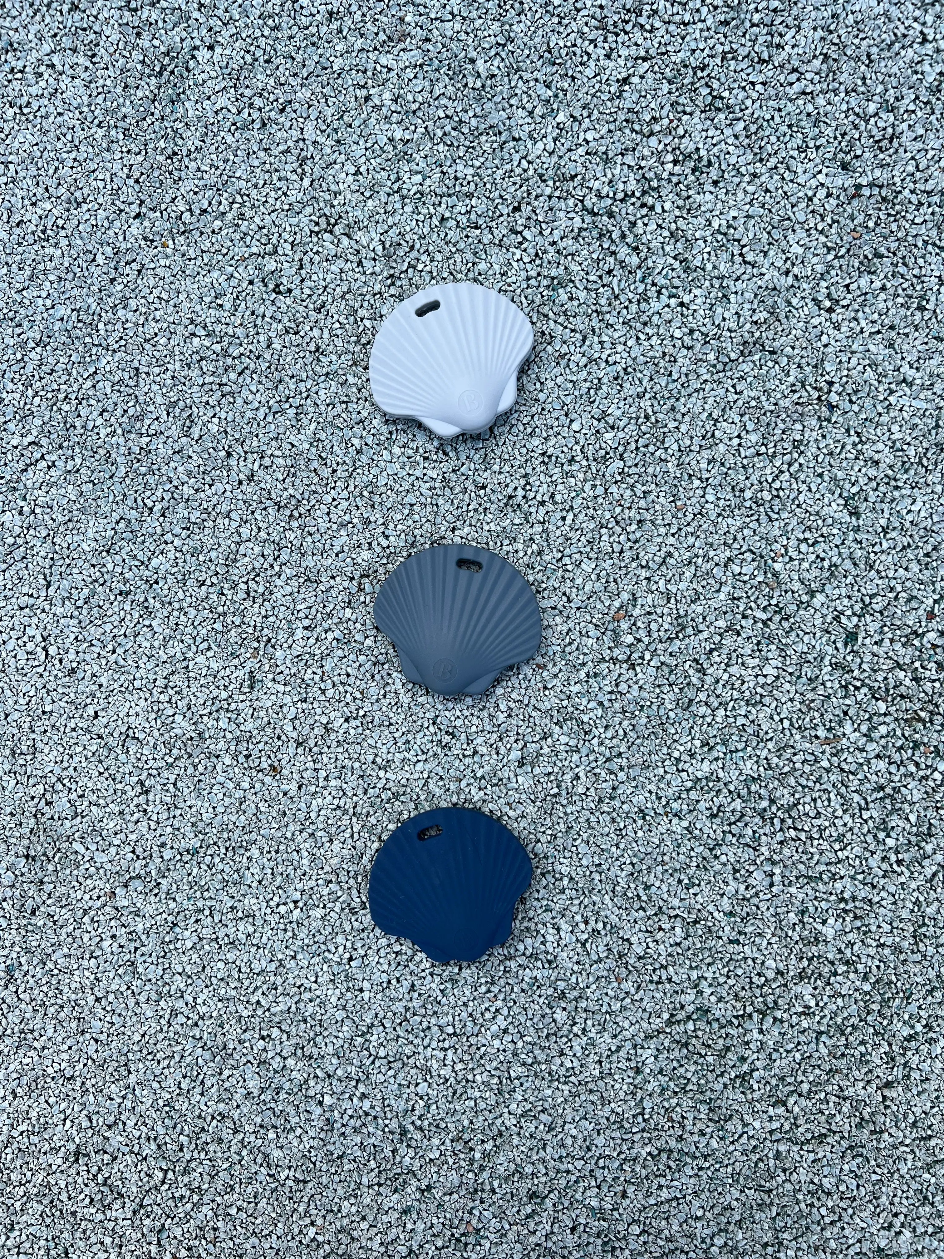 3 Anneaux de dentitions Shell Bleu Ciel, Bleu celeste et gris souris sur un fond pastel, mettant en avant son design adorable et ludique de coquillage, par Bim bam Bloom.