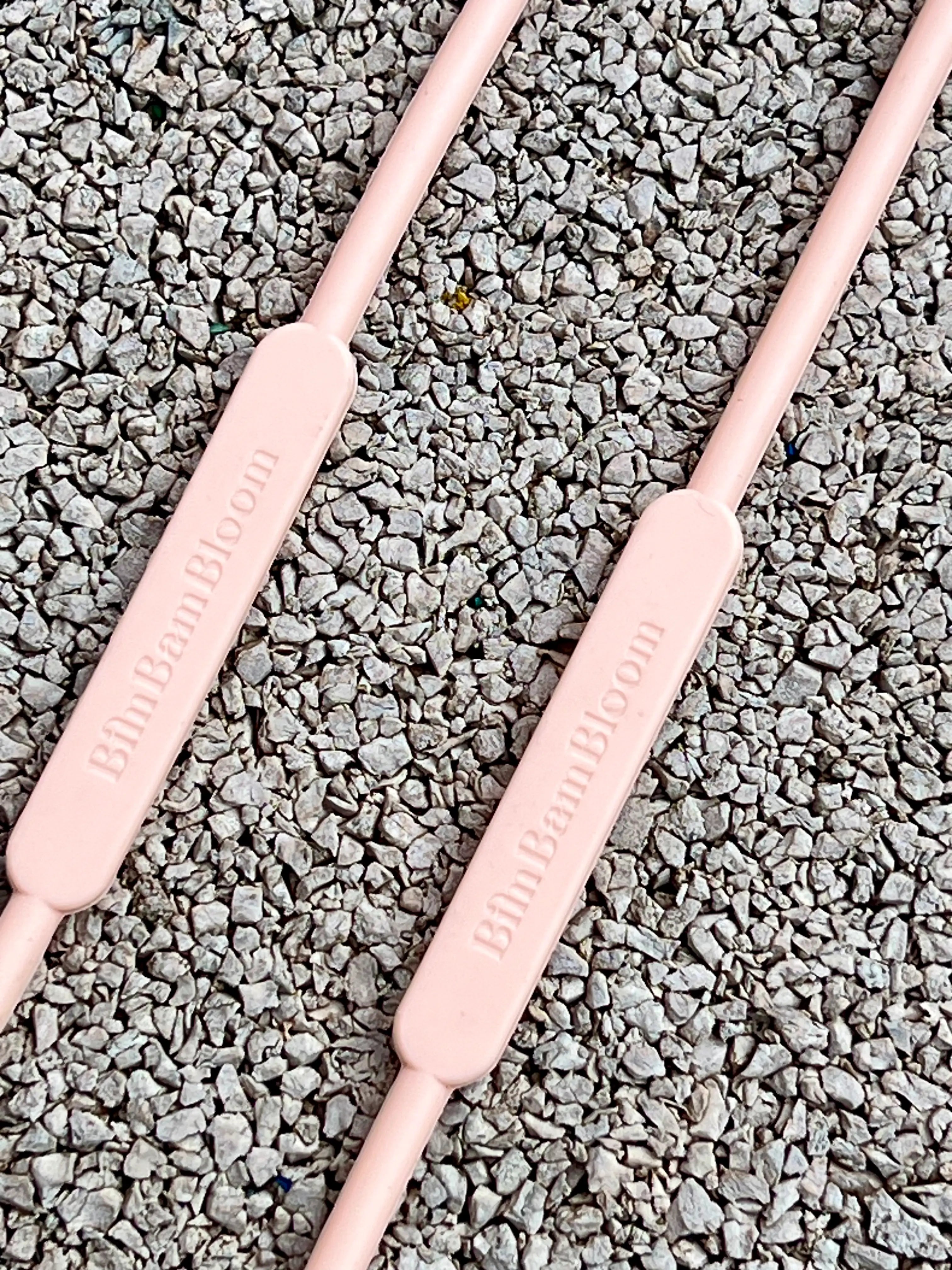 Gros plan sur le logo Bim Bam Bloom de notre attache doudou pour poussette Lovie Link. Cet accessoire pour bébé est indispensable et révolutionnaire. Nos laisses à doudou s'accrochent partout : poussette, voiture, table à langer et chaise haute de bébé.