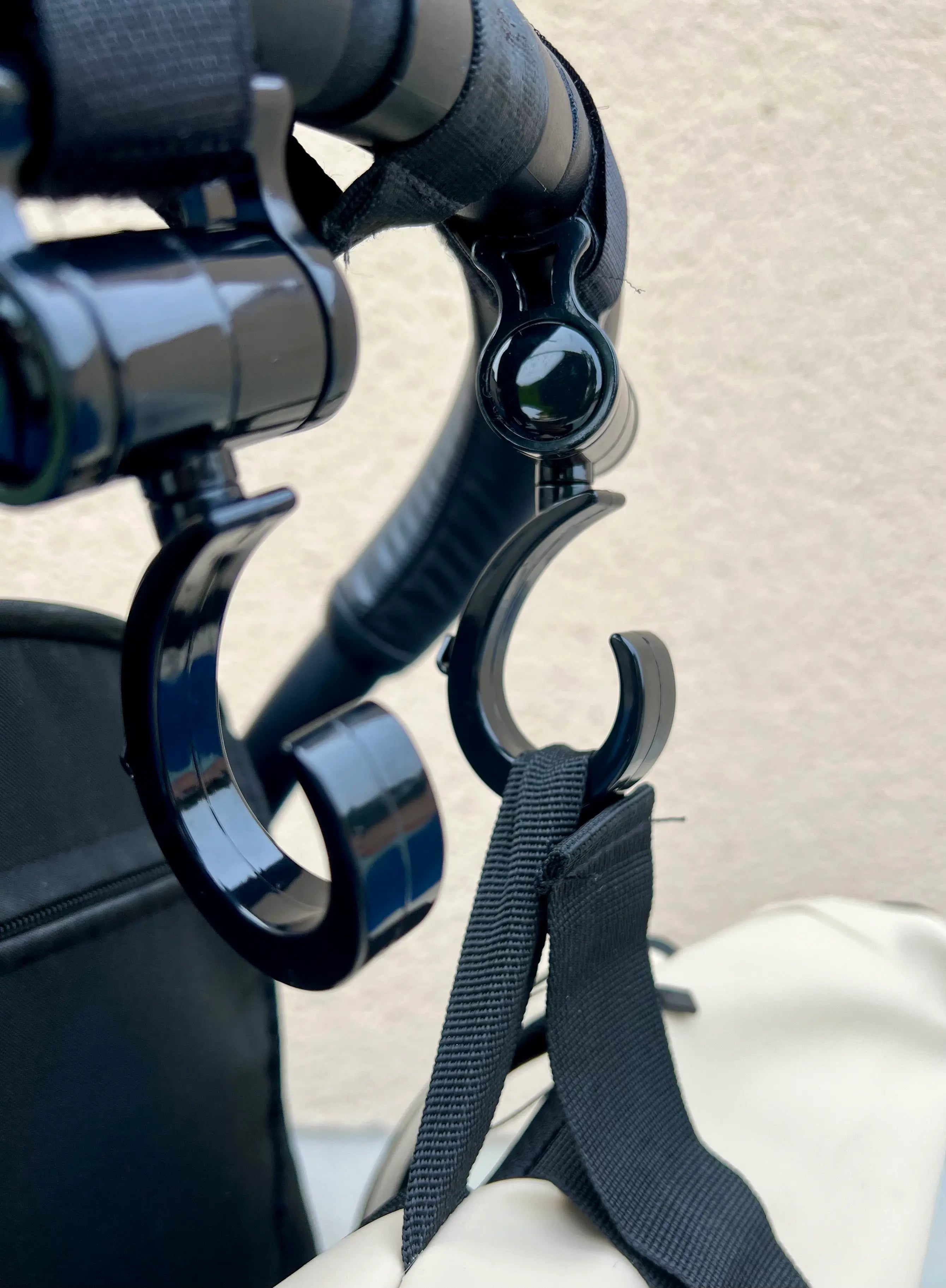 Deuc crochets pour poussette sur une poussette : Transportez vos affaires en toute sécurité.