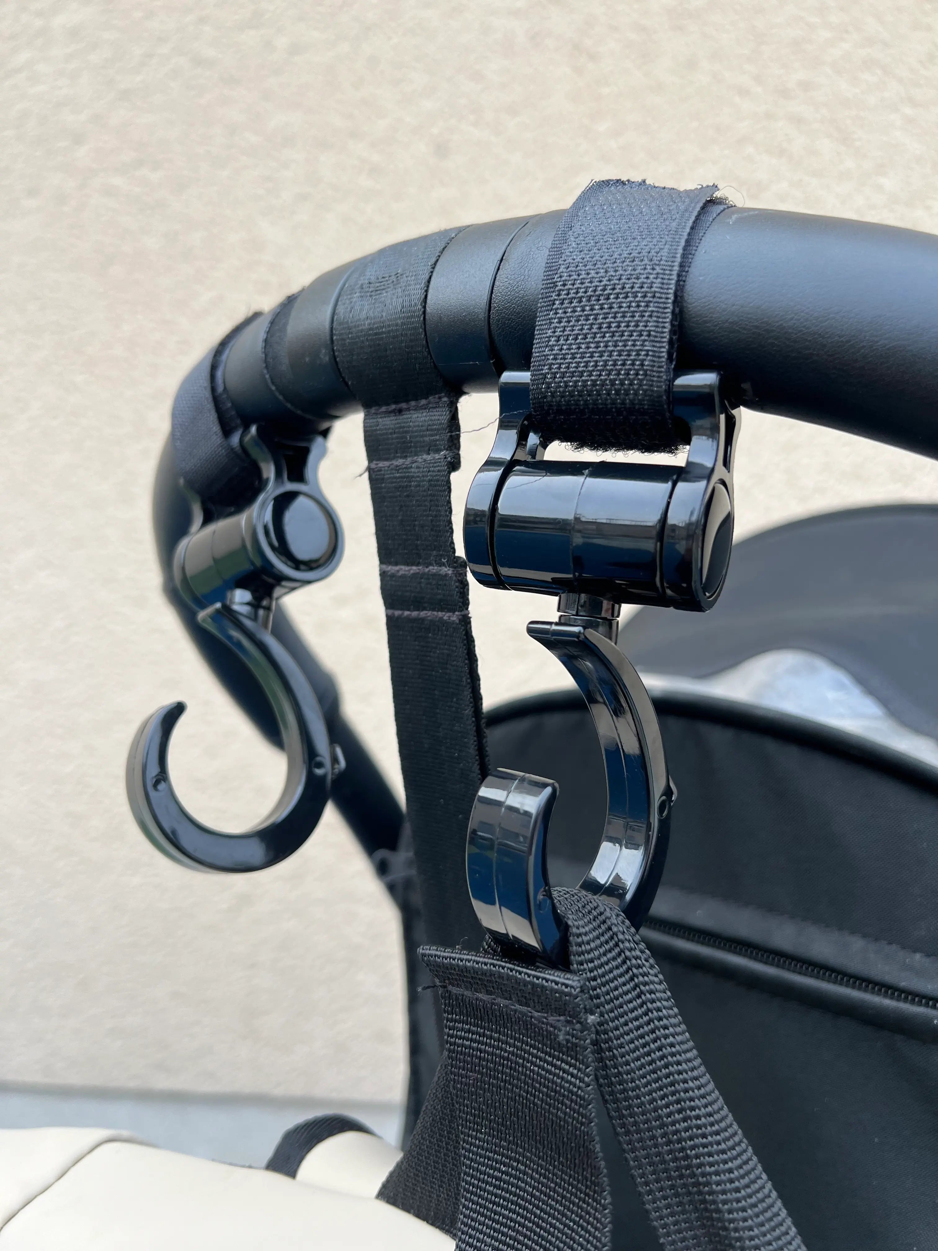 Deux crochets pour poussette attachés à une poussette : Transportez vos affaires en toute sécurité.