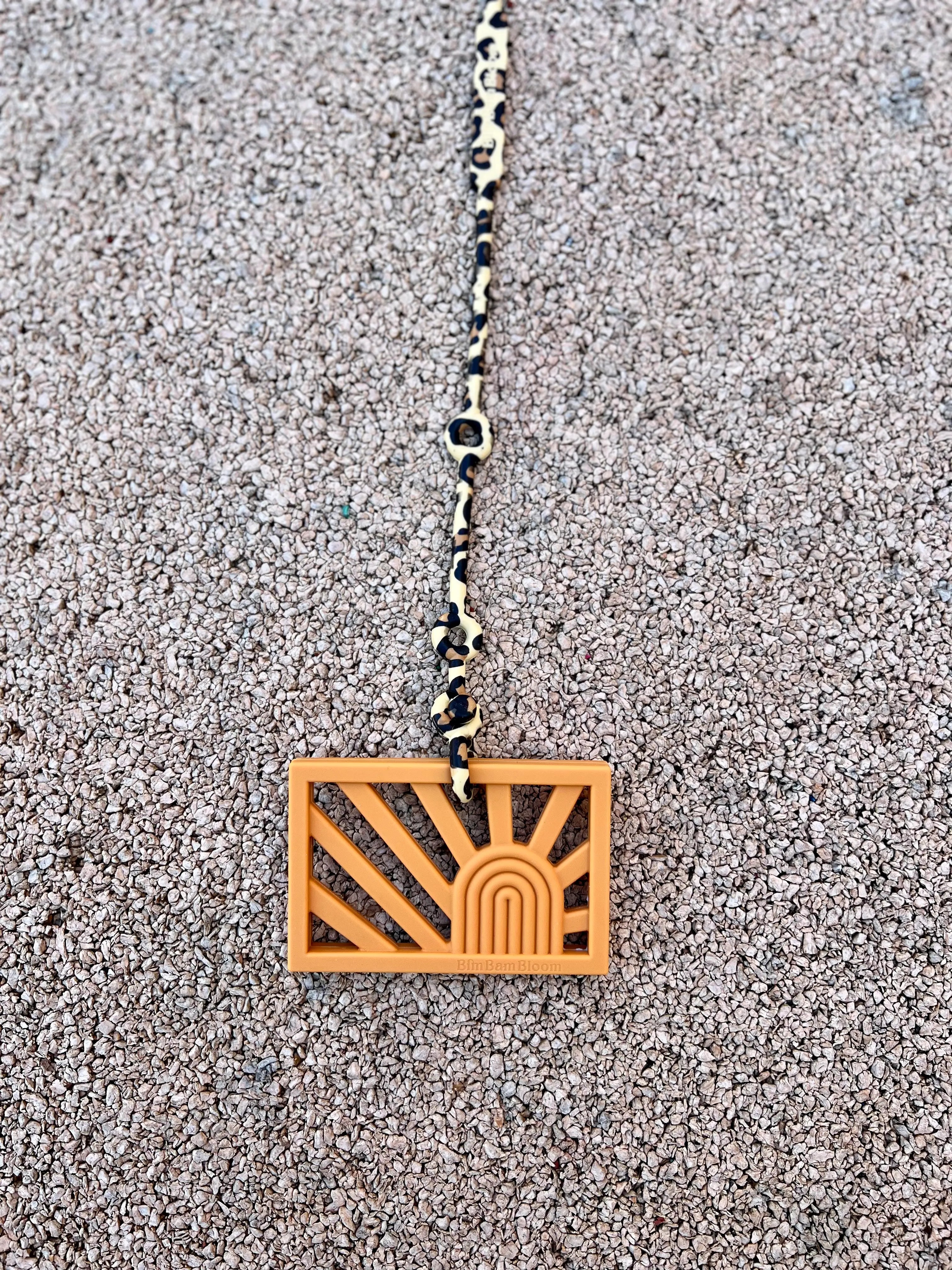 Attache doudou pour poussette et anneau de dentition Bim Bam Bloom. Attache Lovie Link Léopard en silicone sans BPA ni phtalates accroché à notre anneau de dentition Rainbow.