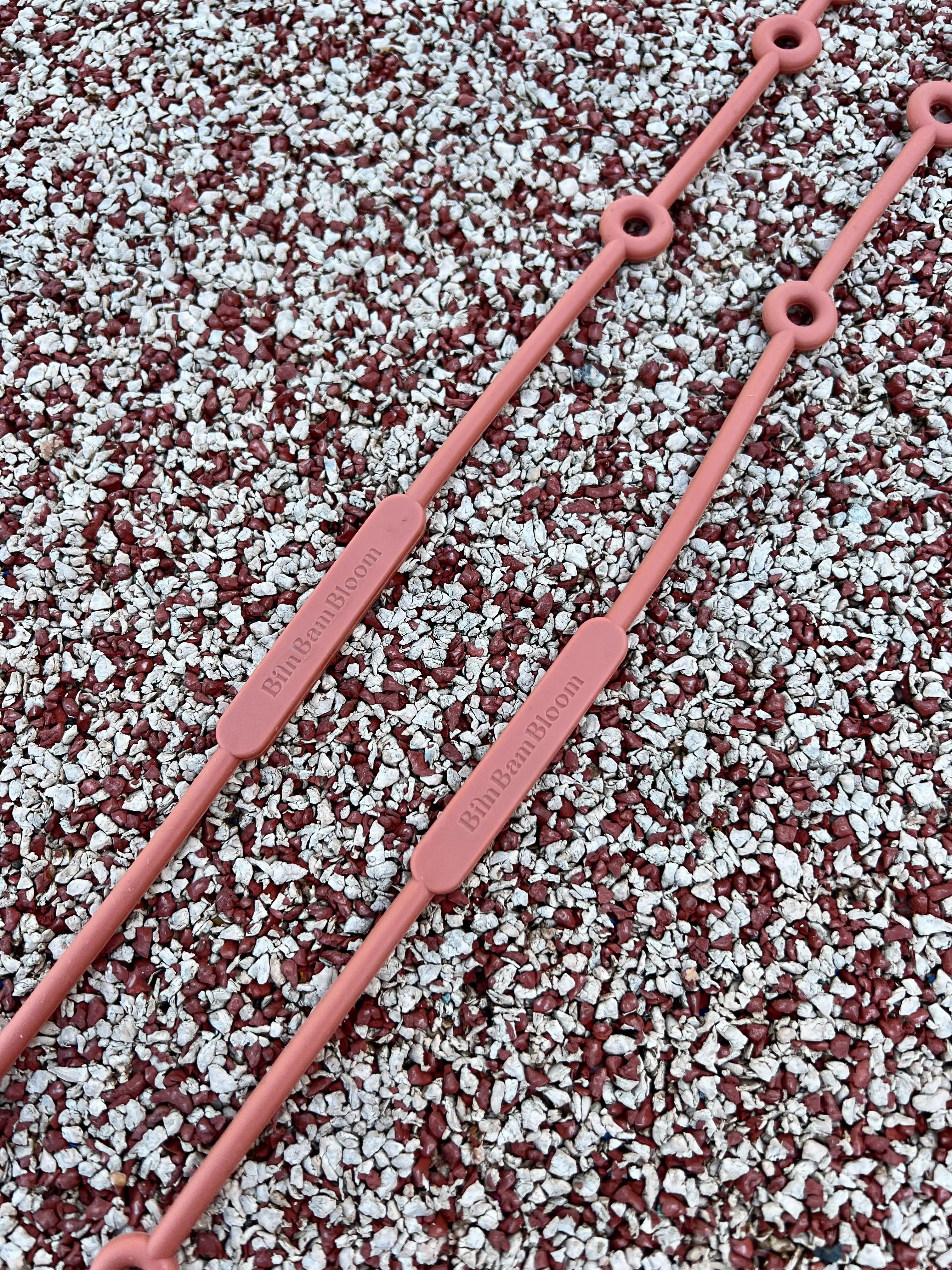 Gros plan sur nos attaches doudou pour poussette Lovie Link Terracotta Bim Bam Bloom en silicone sans BPA ni Phtalates qui se fixe facilement à la poussette de votre bébé. C'est la solution pour ne plus perdre doudou.