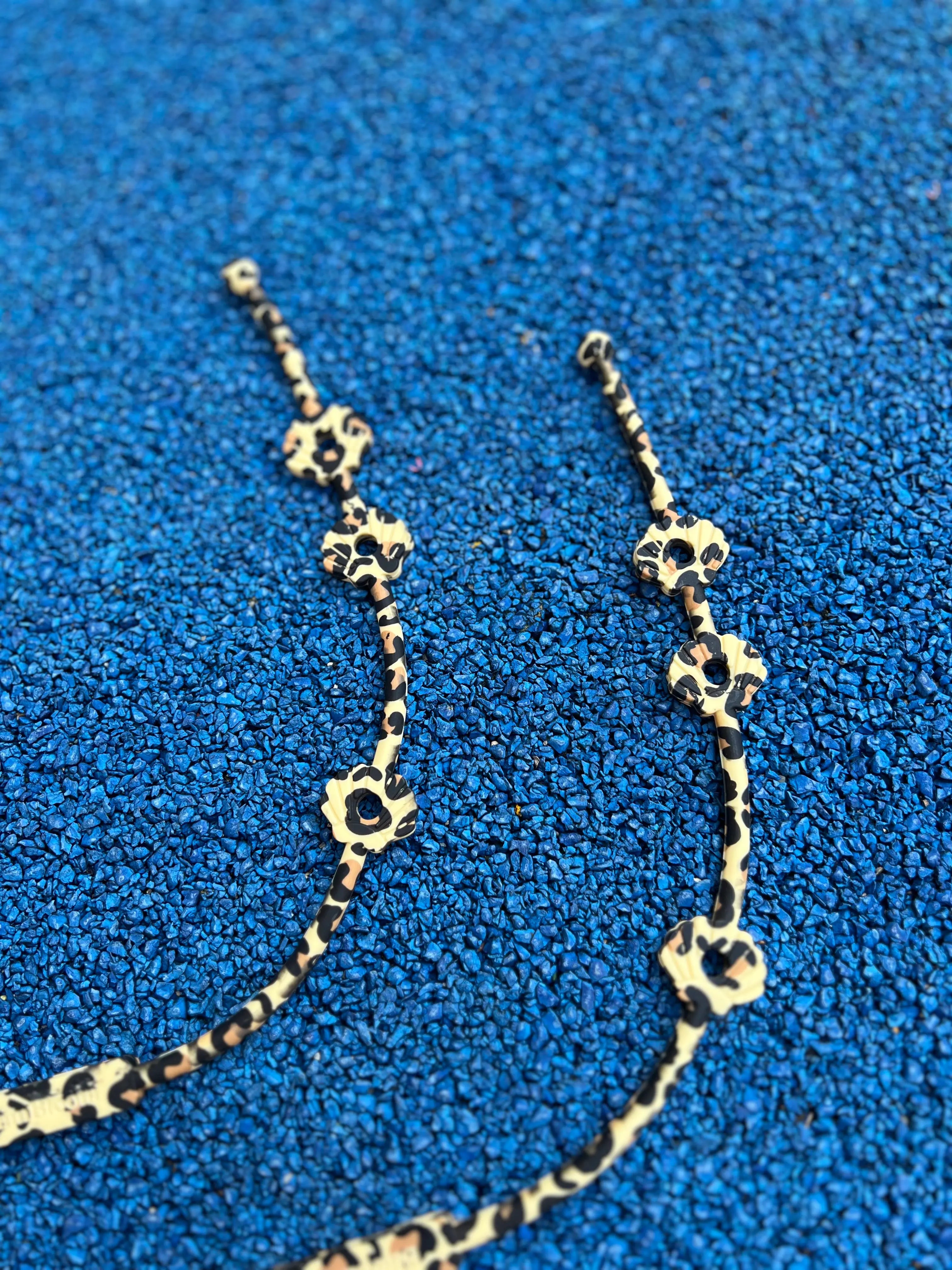 Deux Lovie Link® Shell en imprimé léopard, un accessoire essentiel pour garder le doudou de bébé toujours à portée de main avec style. laisse pour doudou par Bim Bam Bloom.