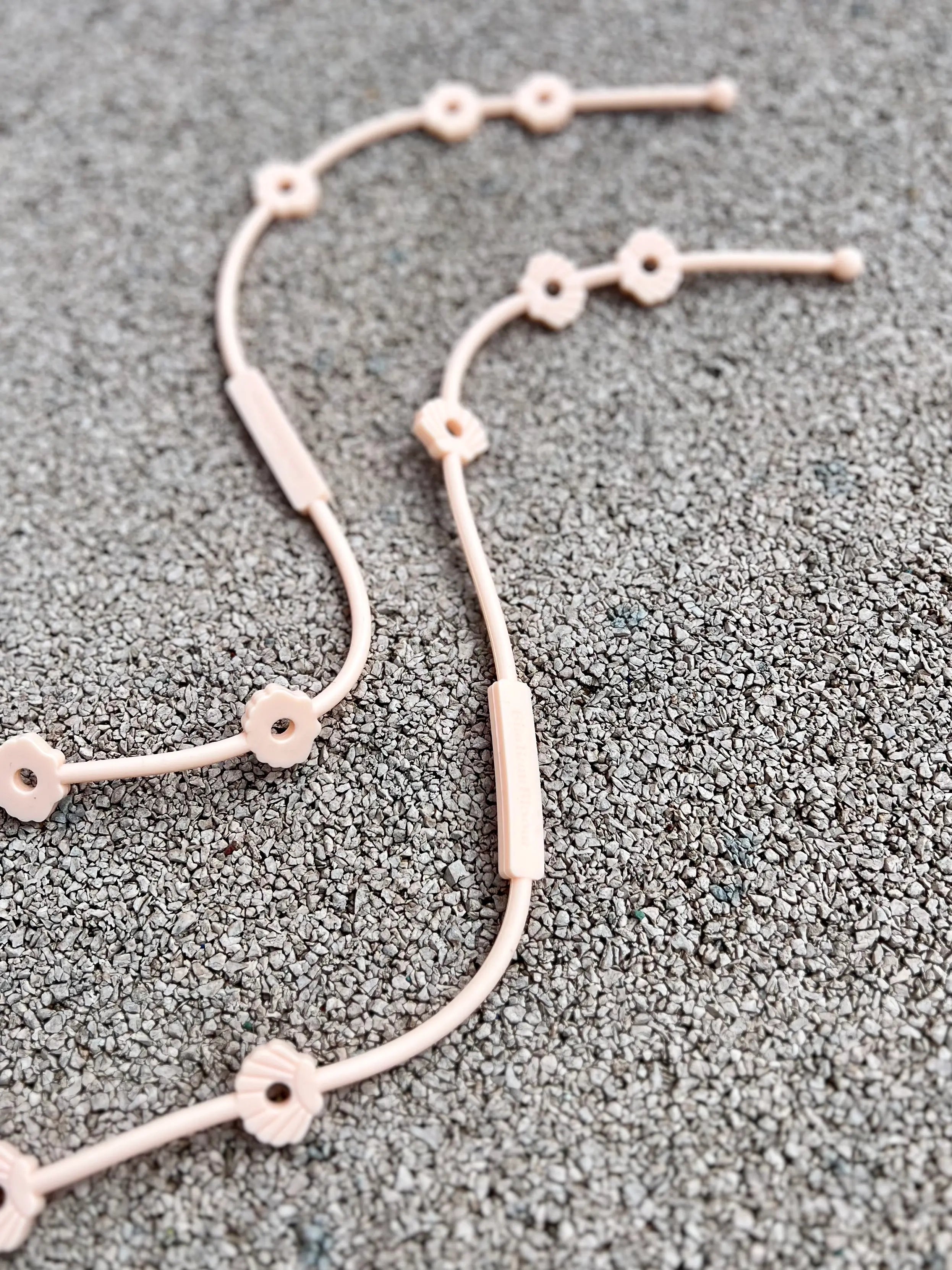 Deux Lovie Link® Shell en rose guimauve fondante, un accessoire essentiel pour garder le doudou de bébé toujours à portée de main par Bim Bam Bloom.