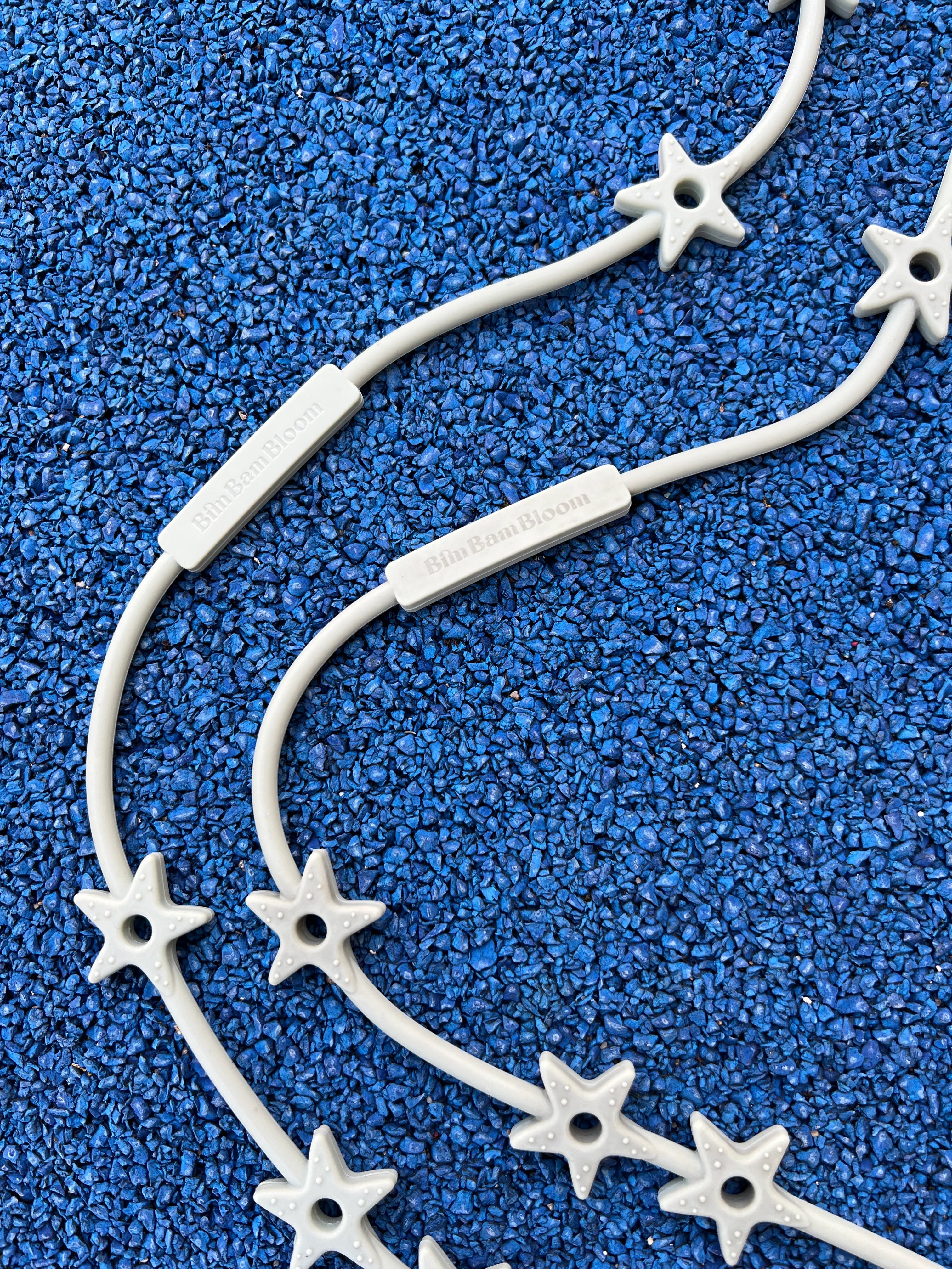 Gros plan sur les étoiles texturées de nos attaches doudous Lovie Link® Star Bim Bam Bloom en vert crème glacée pistache, un accessoire indispensable pour garder le doudou de bébé toujours à portée de main.