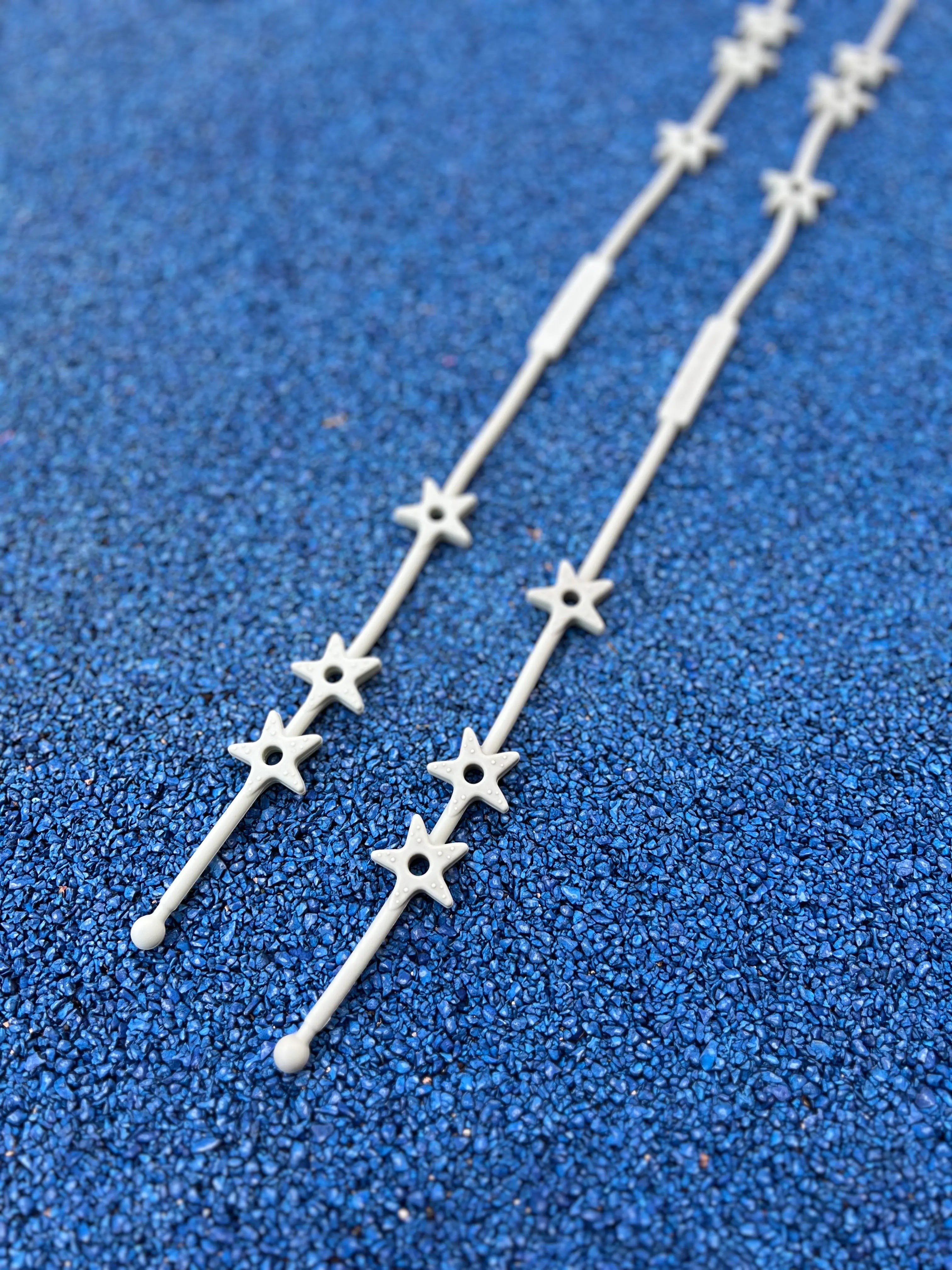 Gros plan sur les étoiles texturées de nos attaches doudous Lovie Link® Star Bim Bam Bloom en vert crème glacée pistache, un accessoire indispensable pour garder le doudou de bébé toujours à portée de main.