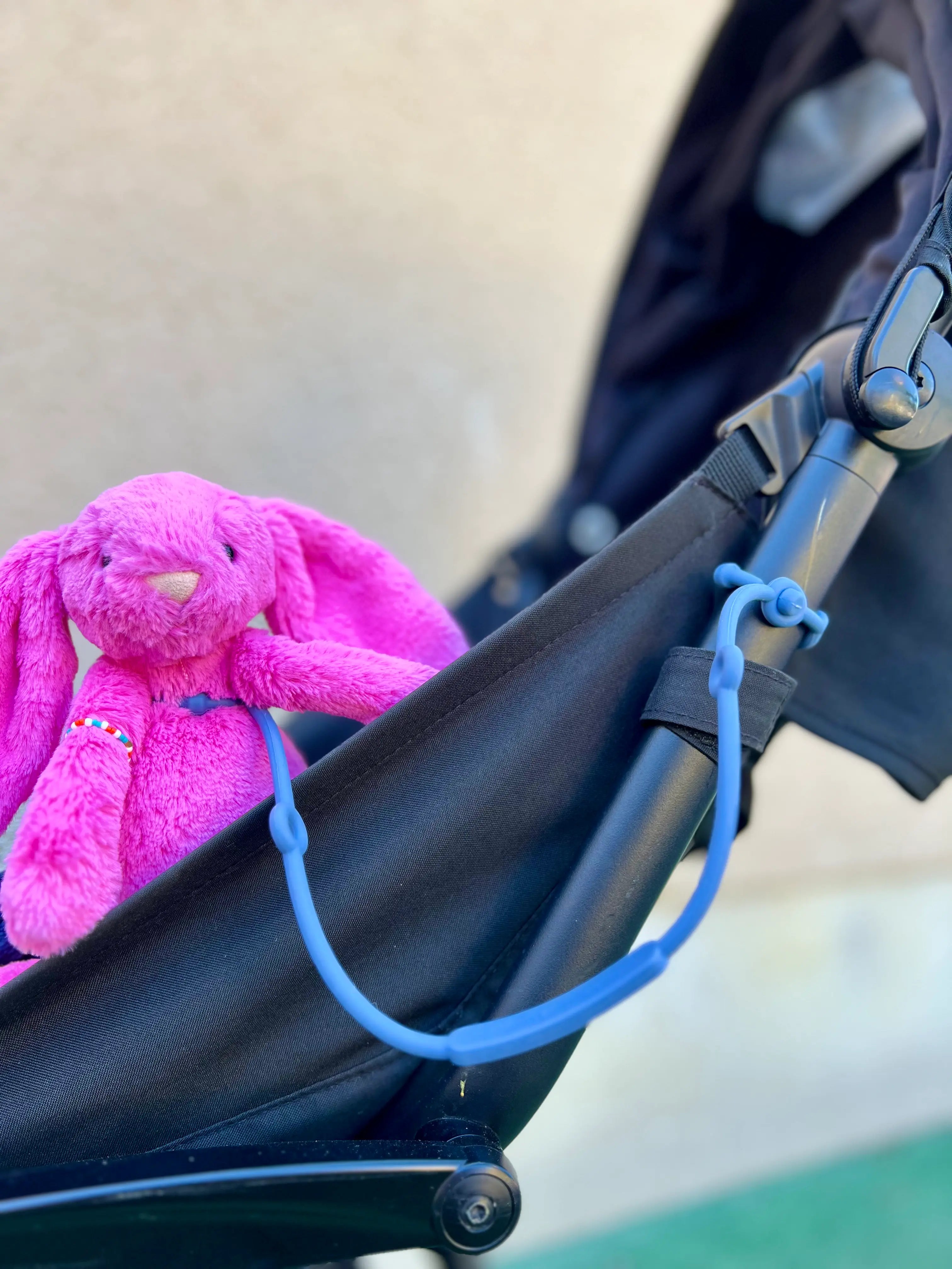 Attache doudou pour poussette Lovie Link par Bim Bam Bloom Bleu Rêve de Farniente sur une poussette. En silicone sans BPA ni phtalates. La solution pour ne plus jamais perdre doudou. Se fixe facilement à la poussette de votre bébé.