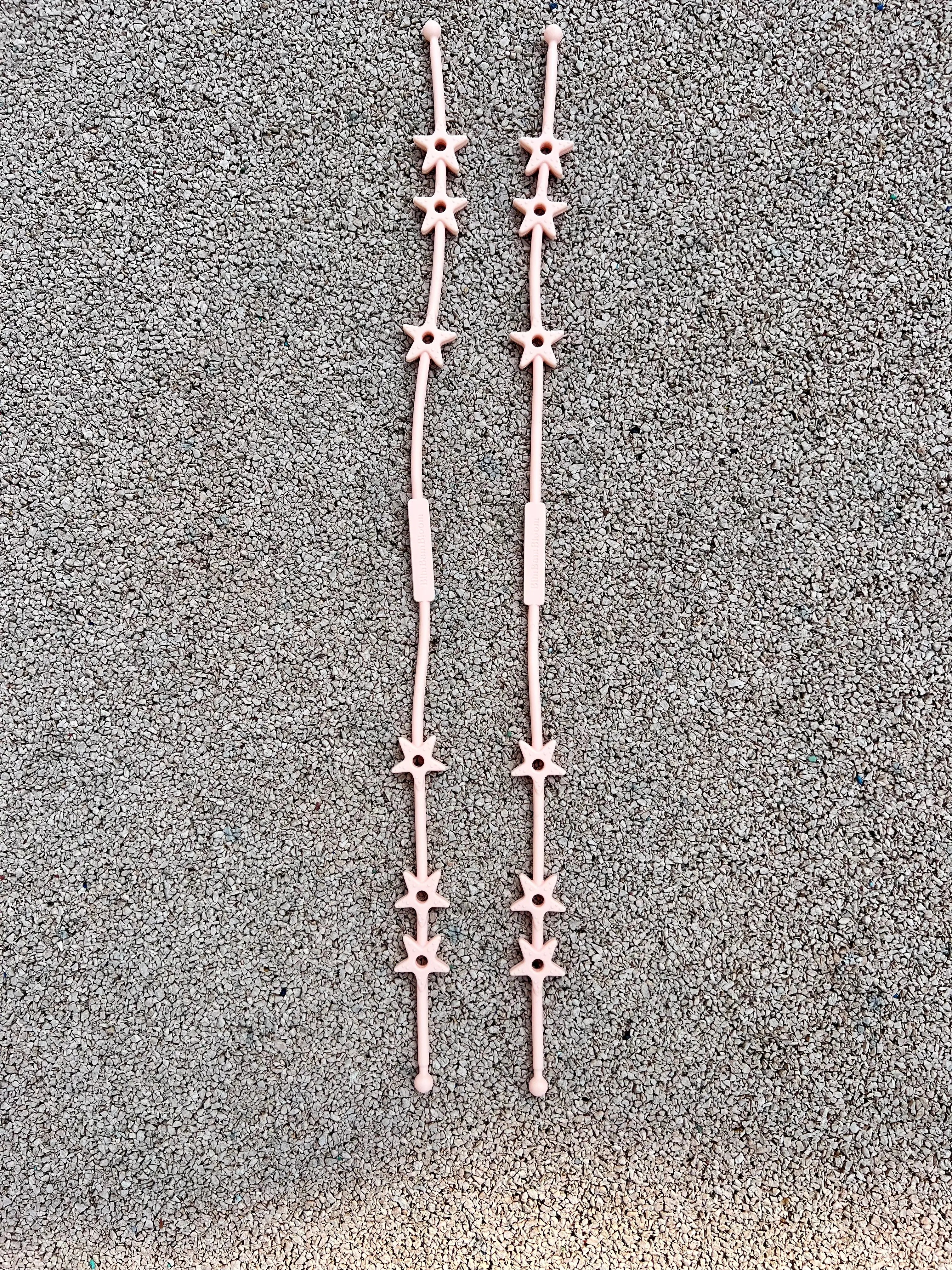 Attache doudou pour poussette Lovie Link® Star rose guimauve fondante sur un fond rose pastel, mettant en avant son design adorable et tendance. Bim Bam Bloom.