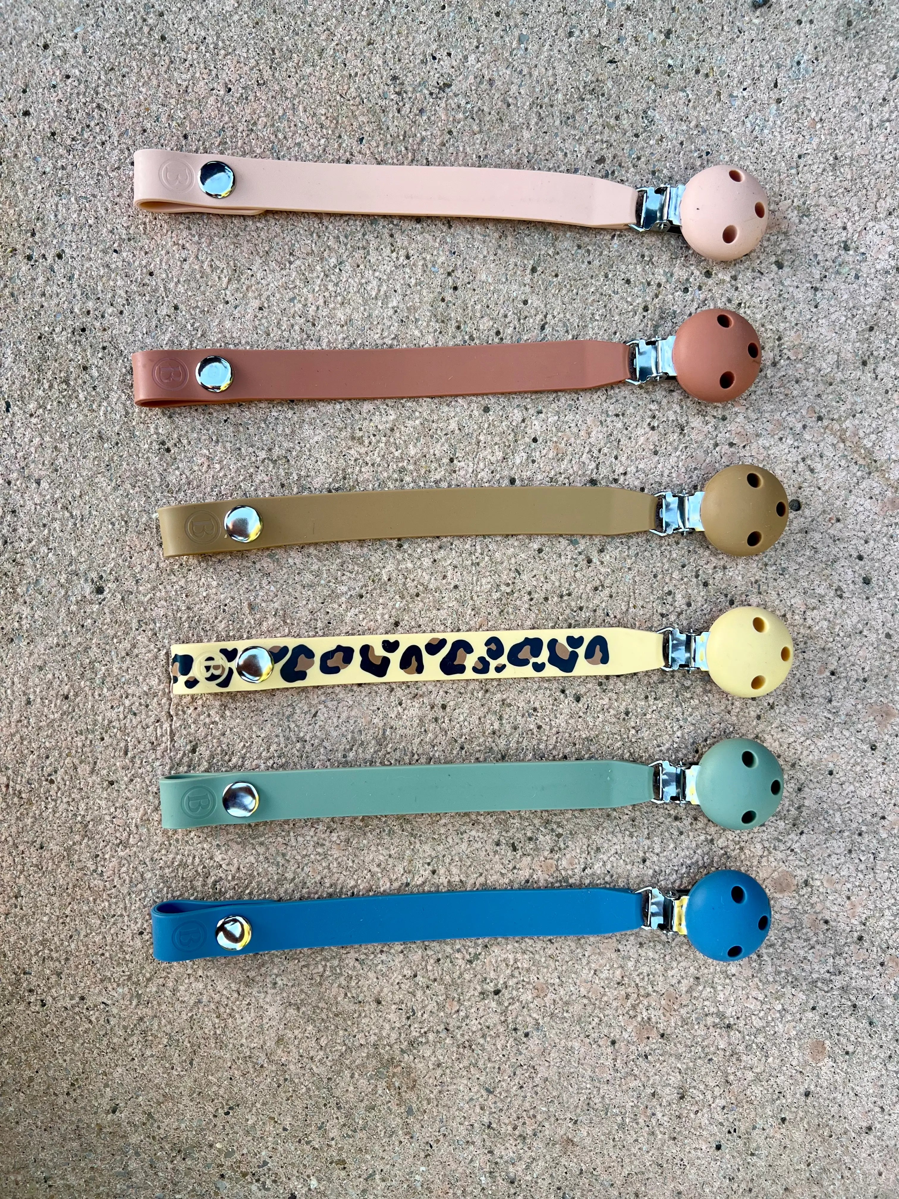 Nos six couleurs d'ttache tetine en silicone sans BPA ni phtalates Bim Bam Bloom.