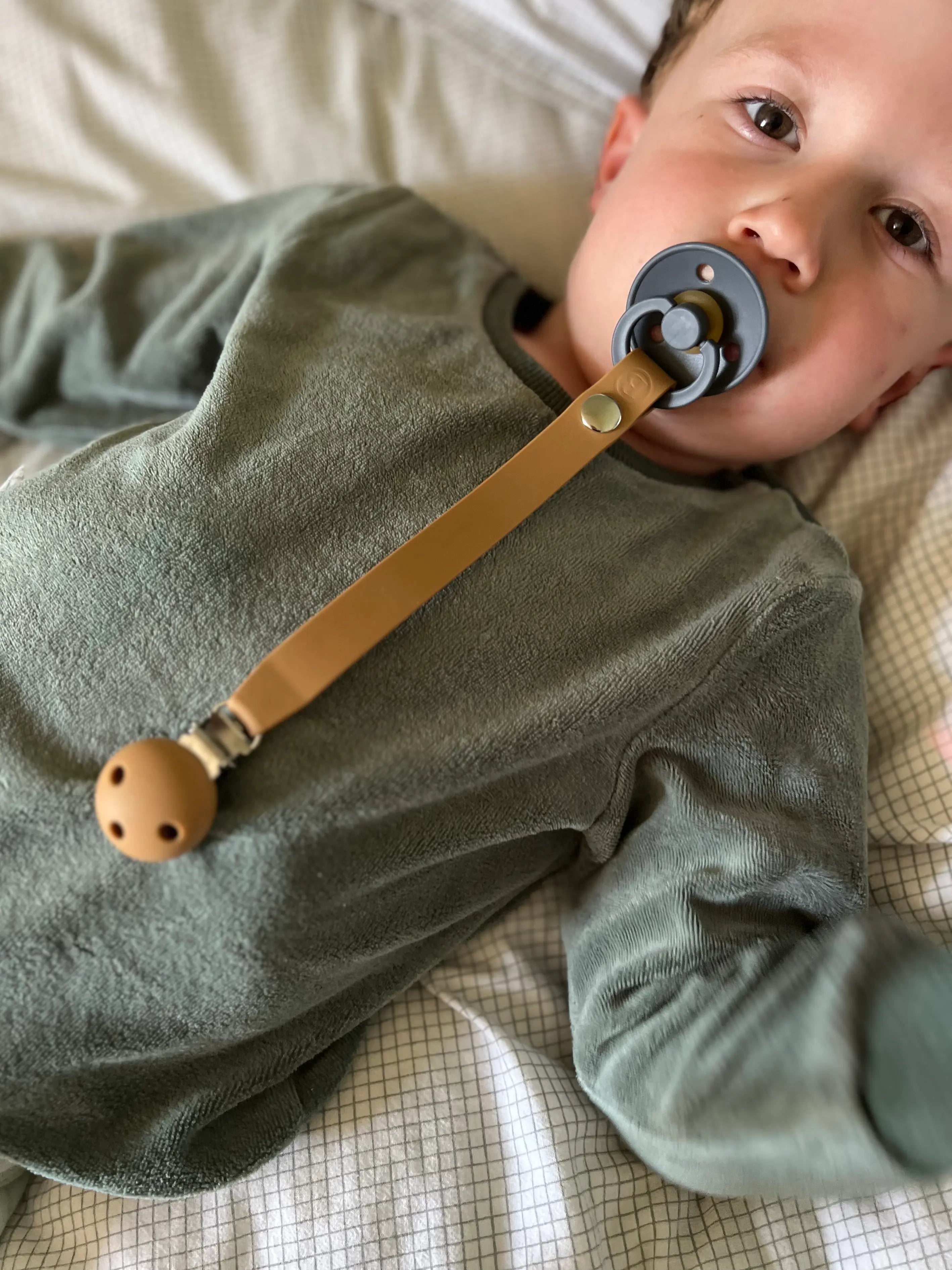 Attache tetine en silicone Camel Bim Bam Bloom avec un petit garcon.