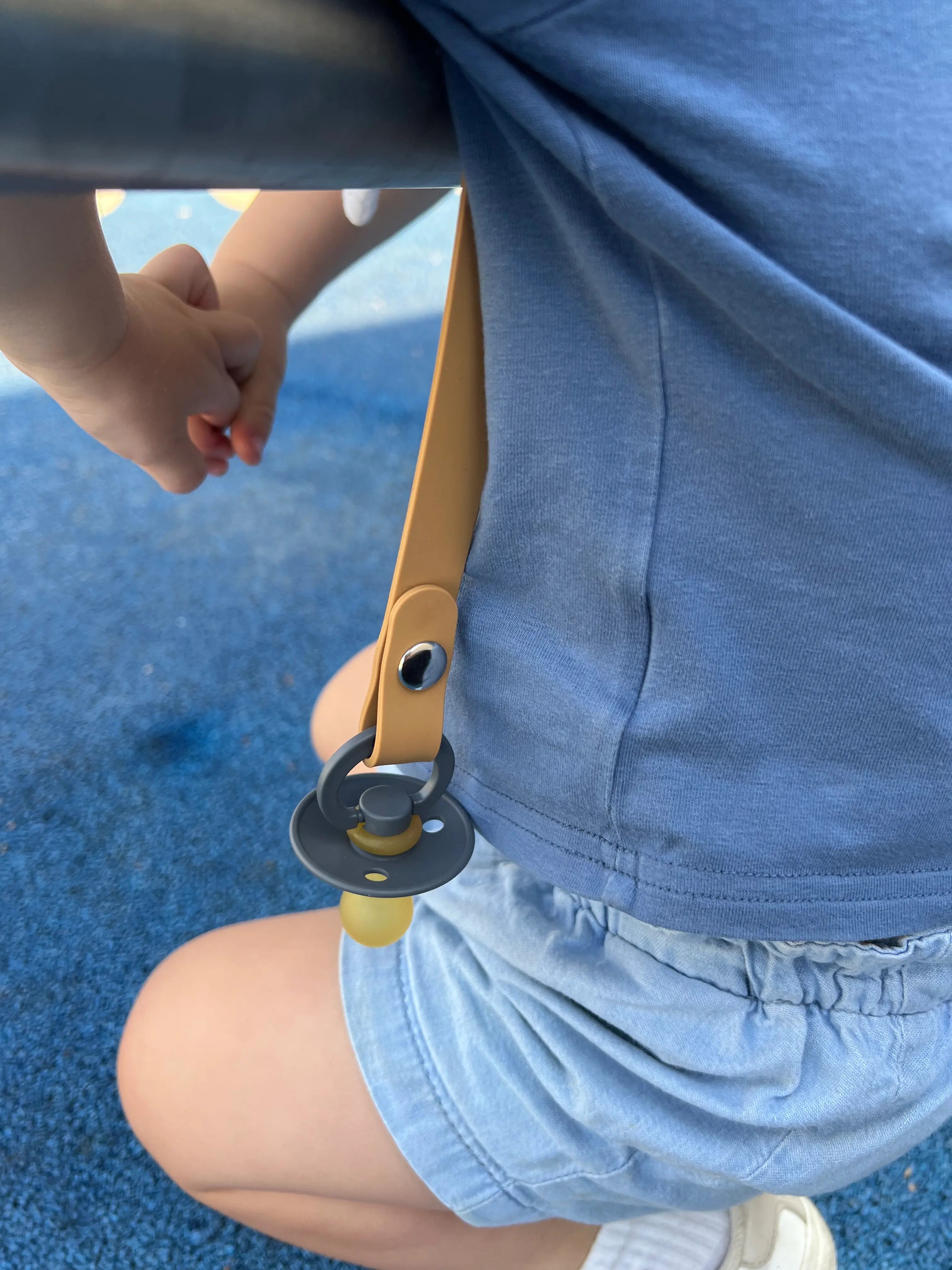 Attache tetine en silicone Camel Bim Bam Bloom portee par un petit garcon.