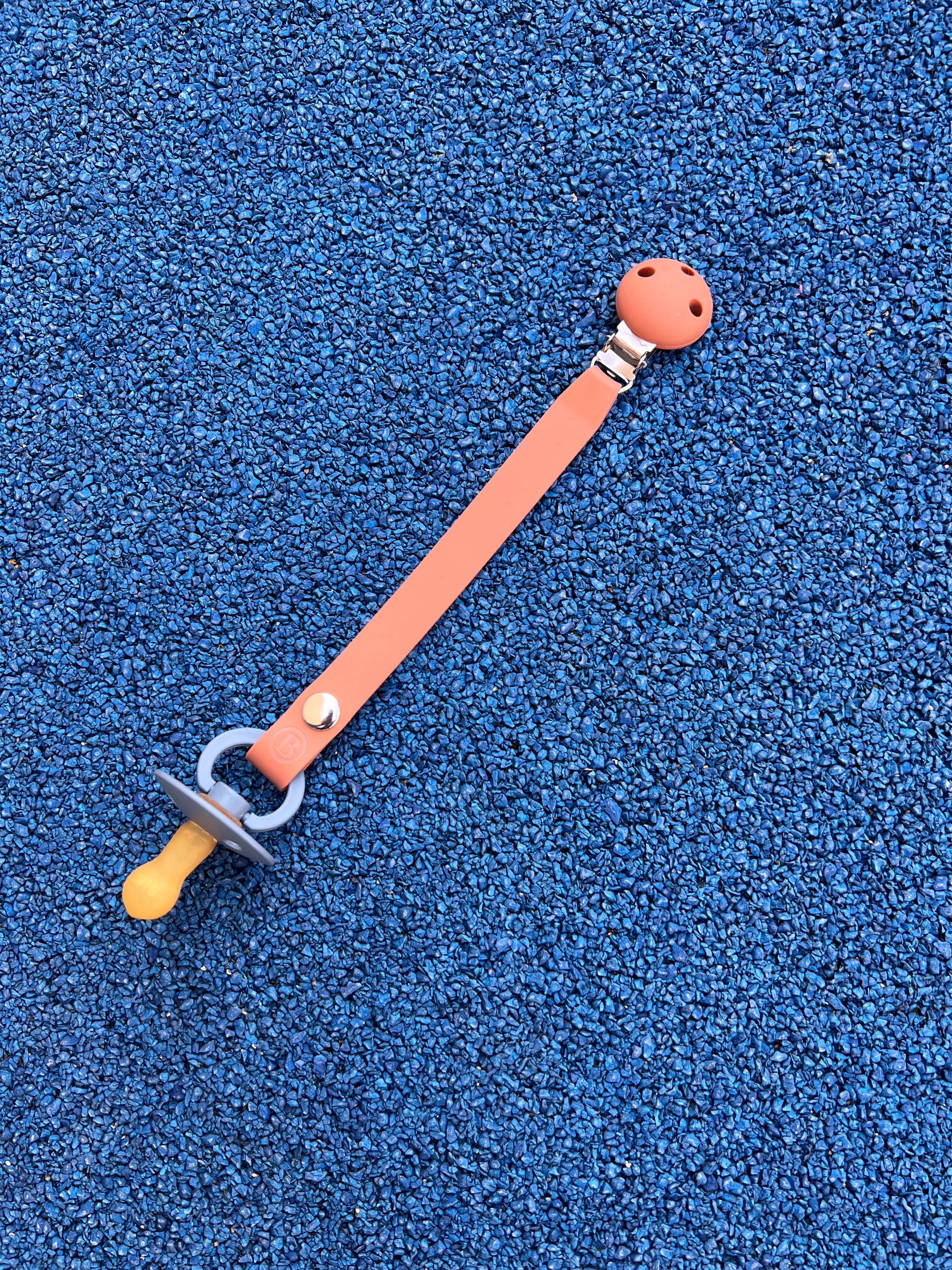 Attache tetine en silicone terracotta Bim Bam Bloom sans BPA ni Phtalates.