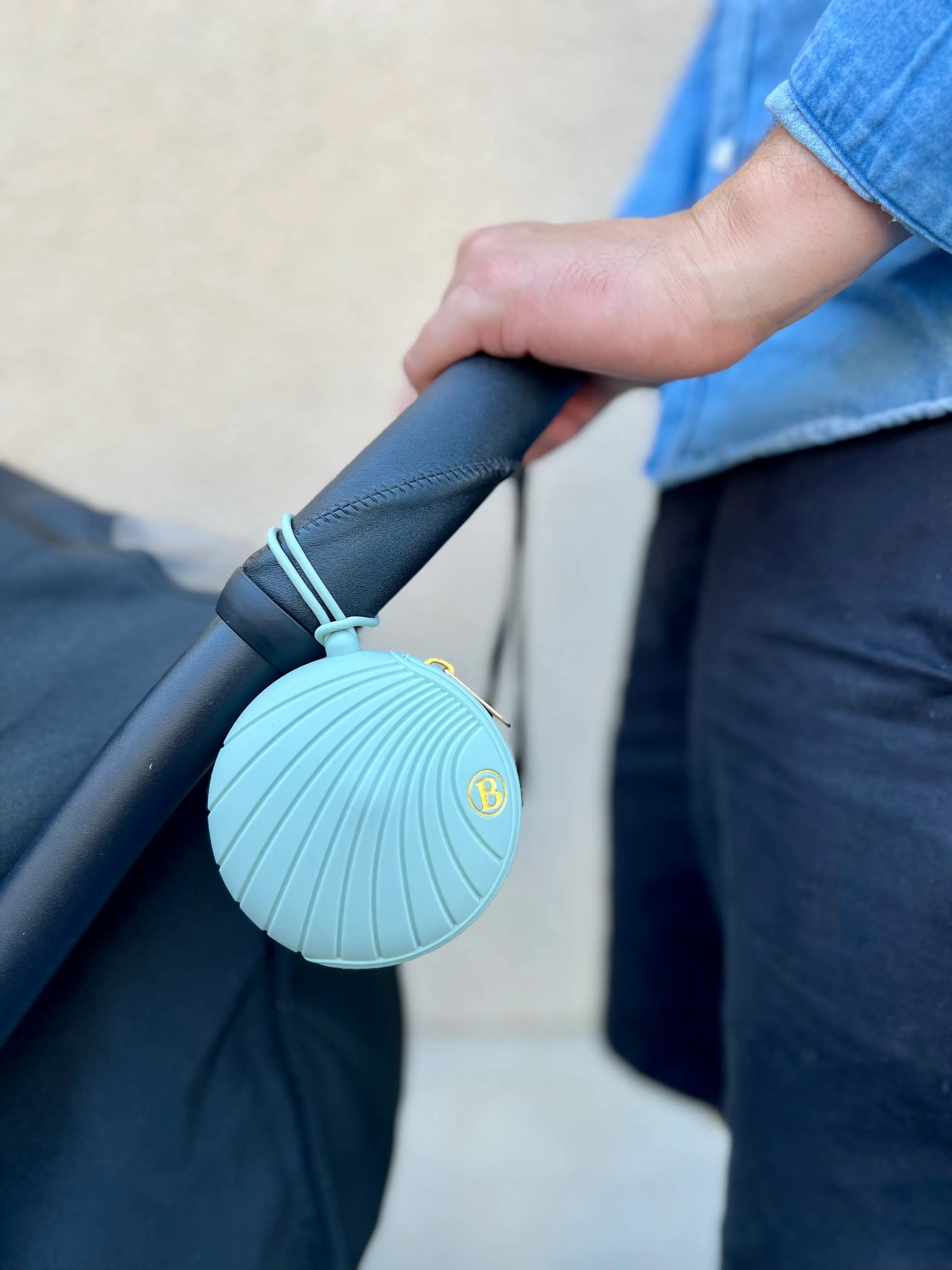Boite a tetine en silicone vert creme glacee pistache se fixant sur tous les supports. La boite a tetine Bim Bam Bloom est attachee sur la poussette.