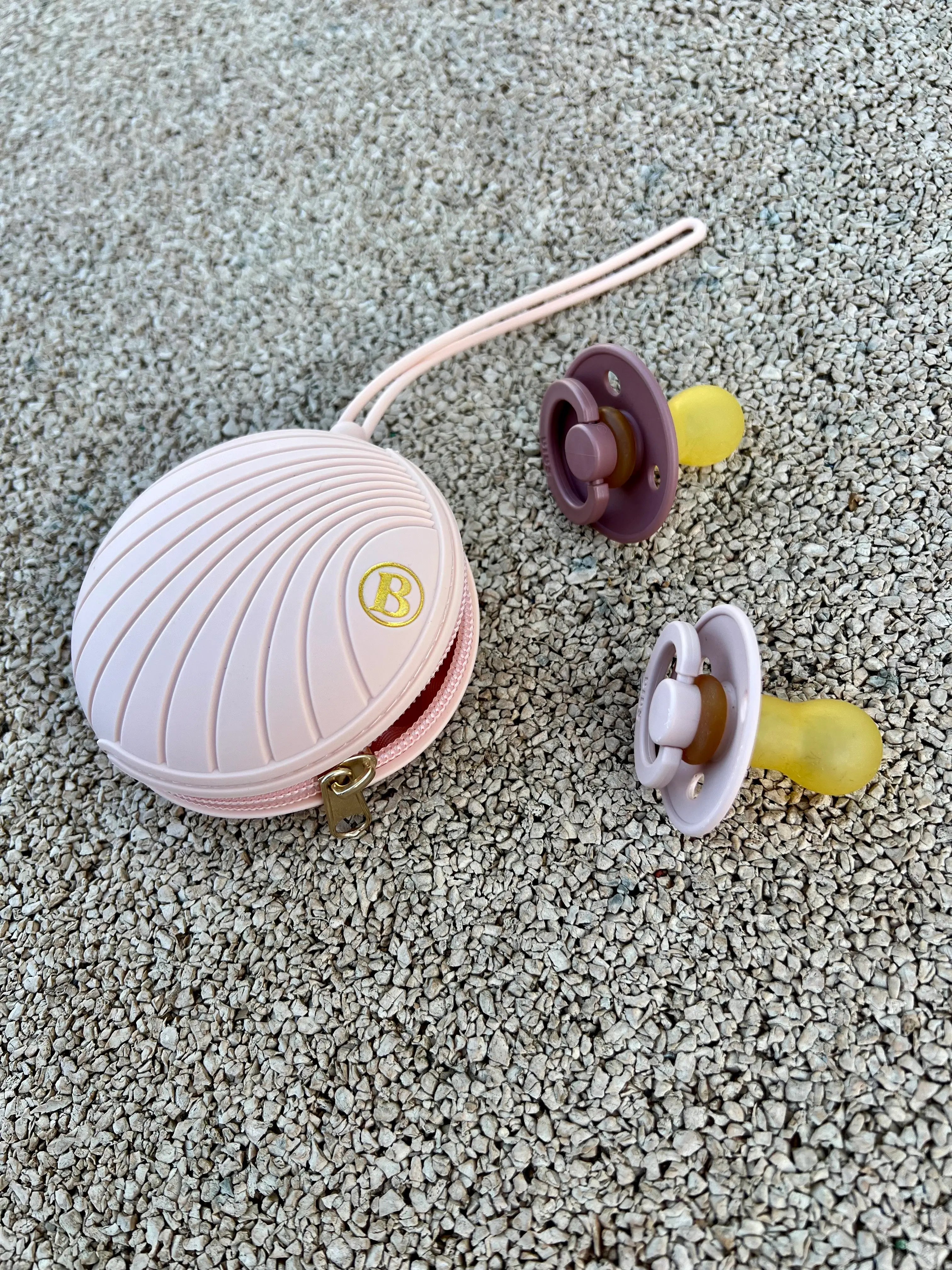 Boite a tetine rose Bim Bam Bloom en silicone pour ranger jusqu'a 4 tetines pour bebe. Elle s'attache a toutes les poussettes et supports