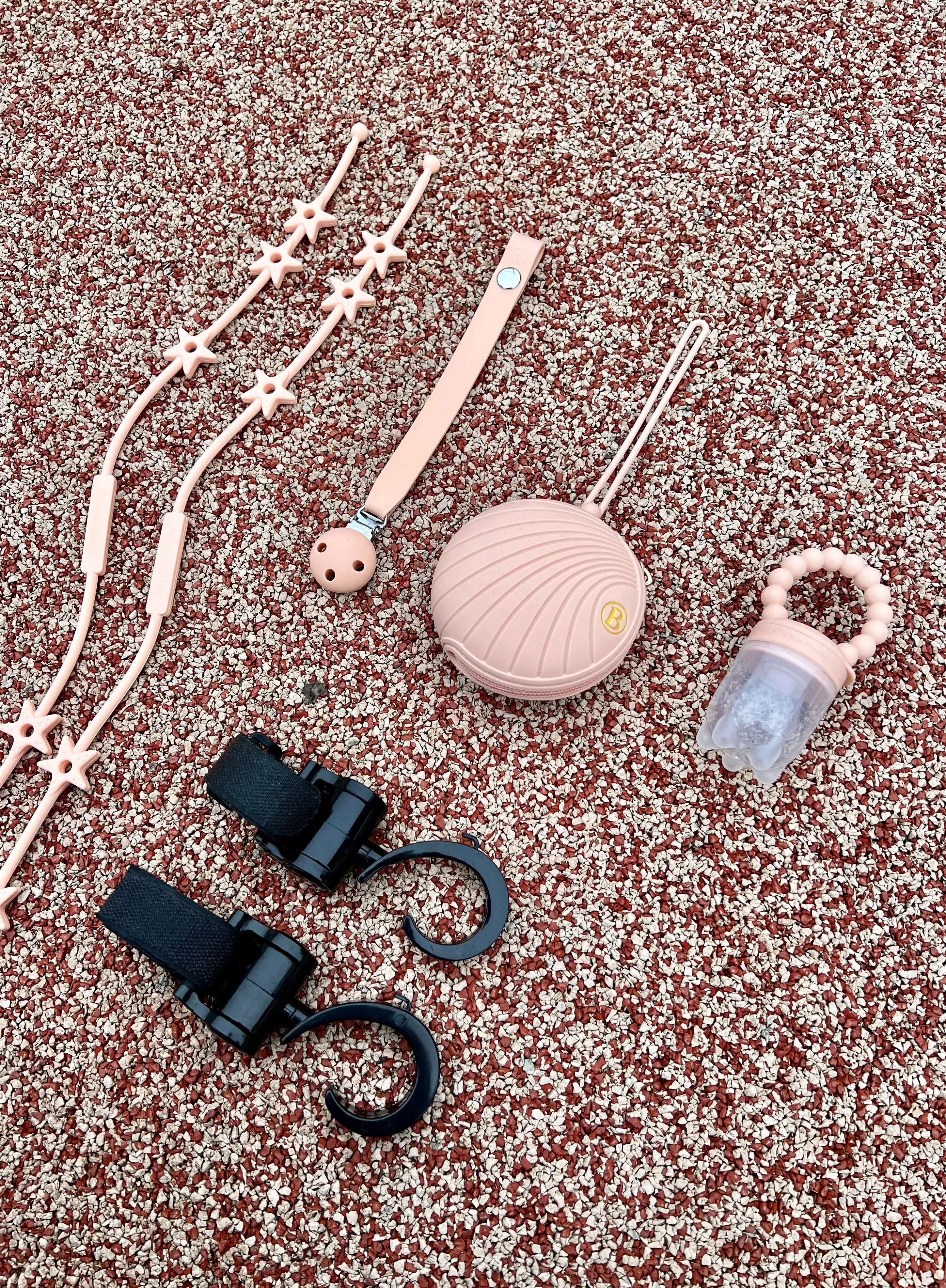 Cadeau de naissance pour bébé fille au design d'étoiles en rose. Notre coffret cadeau de naissance comprend une boîte à tétine, un attache-tétine, une tétine gourmande, deux crochets pour poussette et deux Lovie Link Star étoiles Bim Bam Bloom.