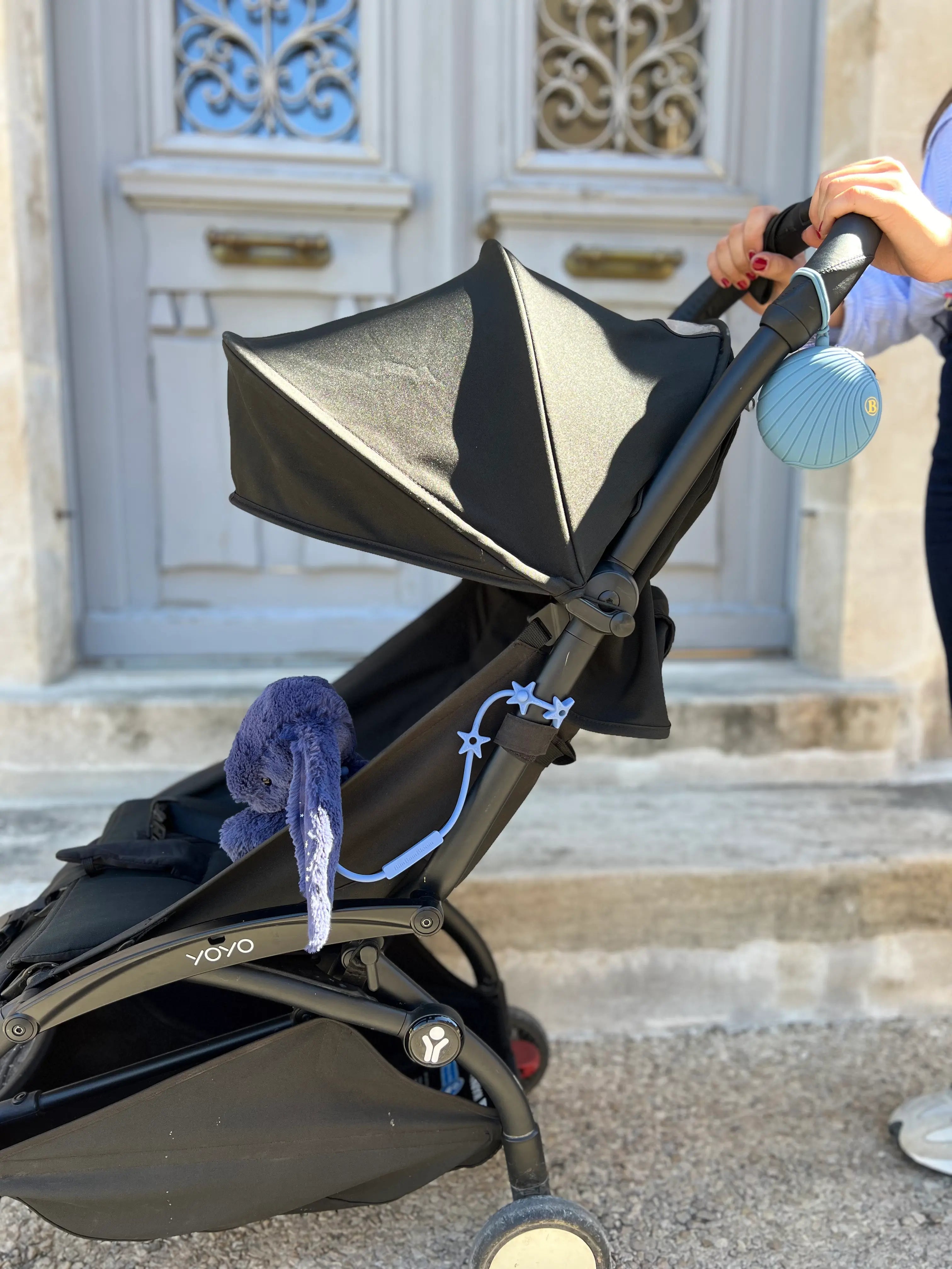 Attache doudou pour poussette Star bleu en silicone Bim Bam Bloom avec boite a tetine sur poussette.