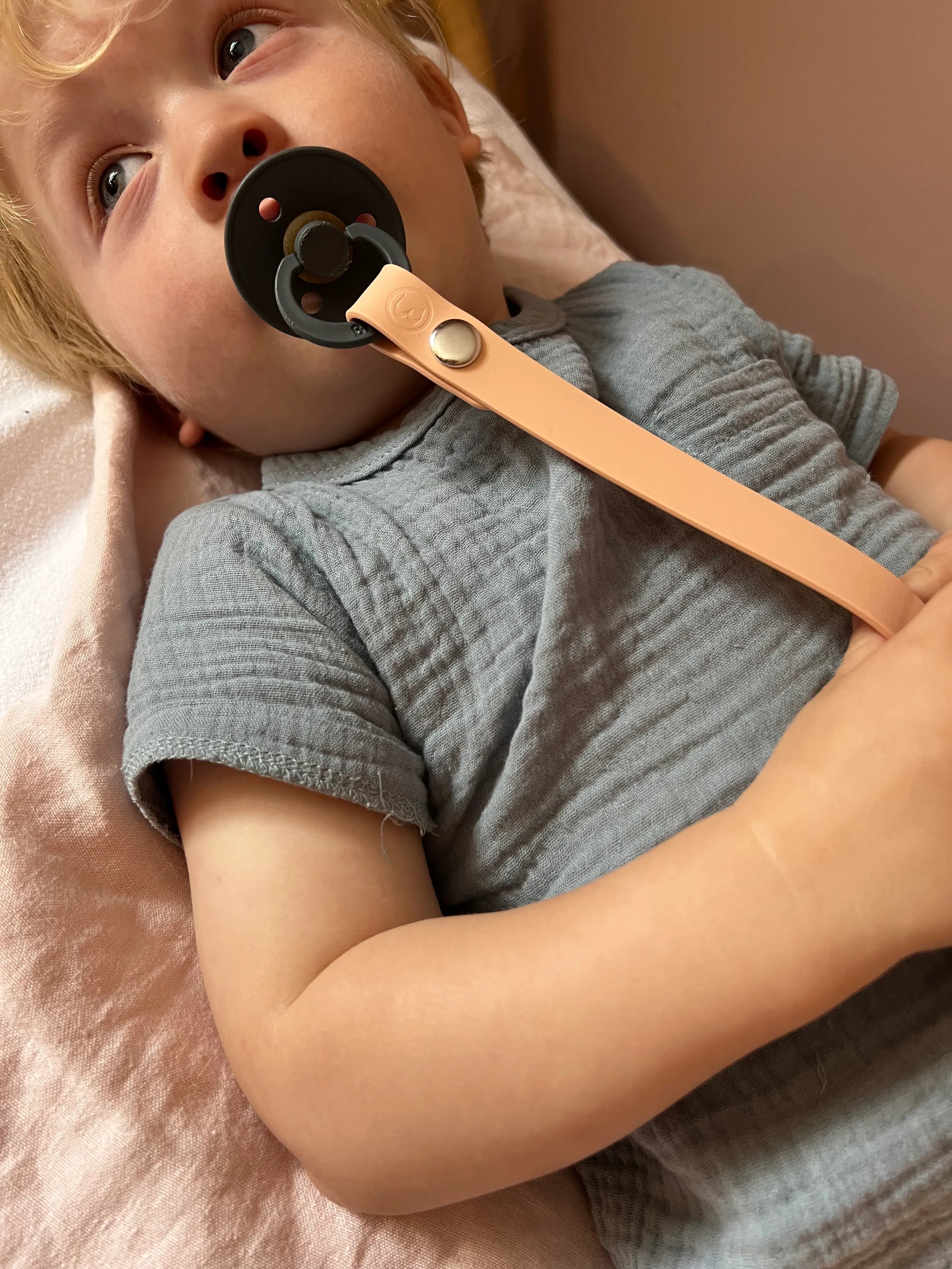 Attache tétine de notre Pack Naissance Bim Bam Bloom en Rose, comprenant tous les essentiels pour bébé : boîte à tétine, attache-tétine, deux Lovie Link®, une tétine grignoteuse Yummy Tot® et deux crochets pour poussette.