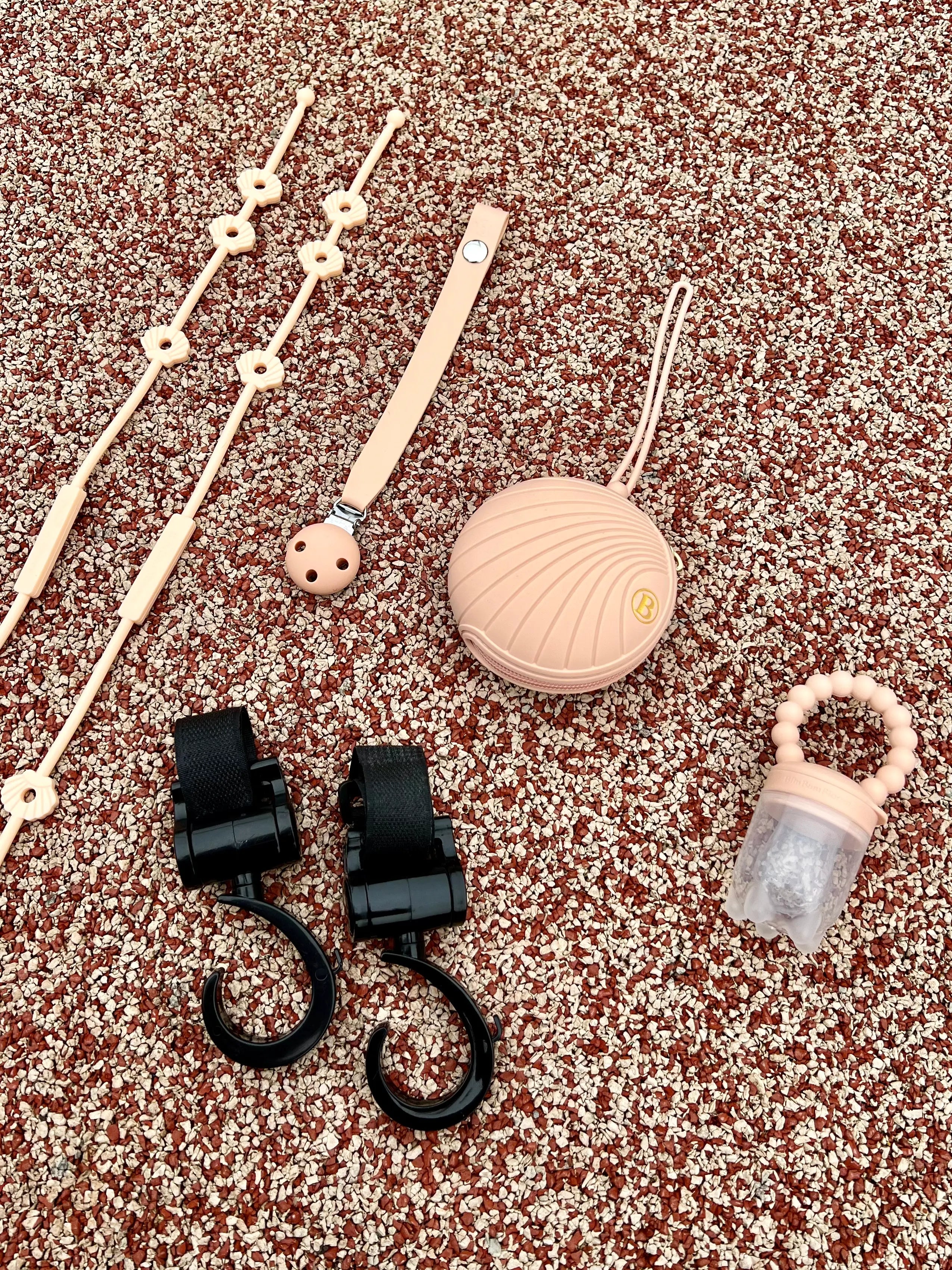 Cadeau de naissance pour bébé fille au design de coquillage en rose. Notre coffret cadeau de naissance comprend une boîte à tétine, un attache-tétine, une tétine gourmande, deux crochets pour poussette et deux Lovie Link Shell coquillage Bim Bam Bloom.