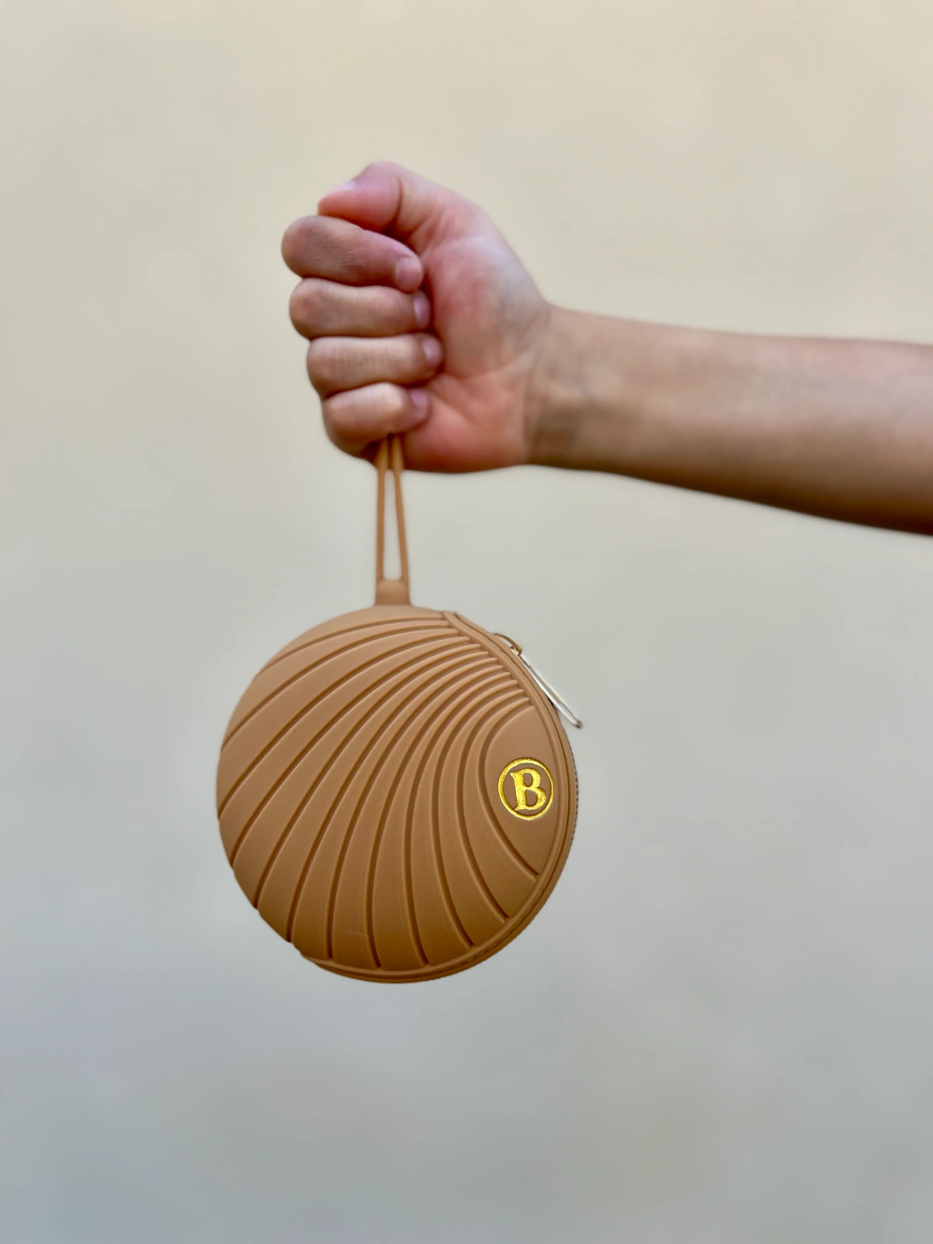 Boîte à tétine Camel Dune Dorée de Bim Bam Bloom, conçue pour protéger et transporter la tétine de bébé avec style et hygiène dans la main d'une petite fille par Bim Bam Bloom