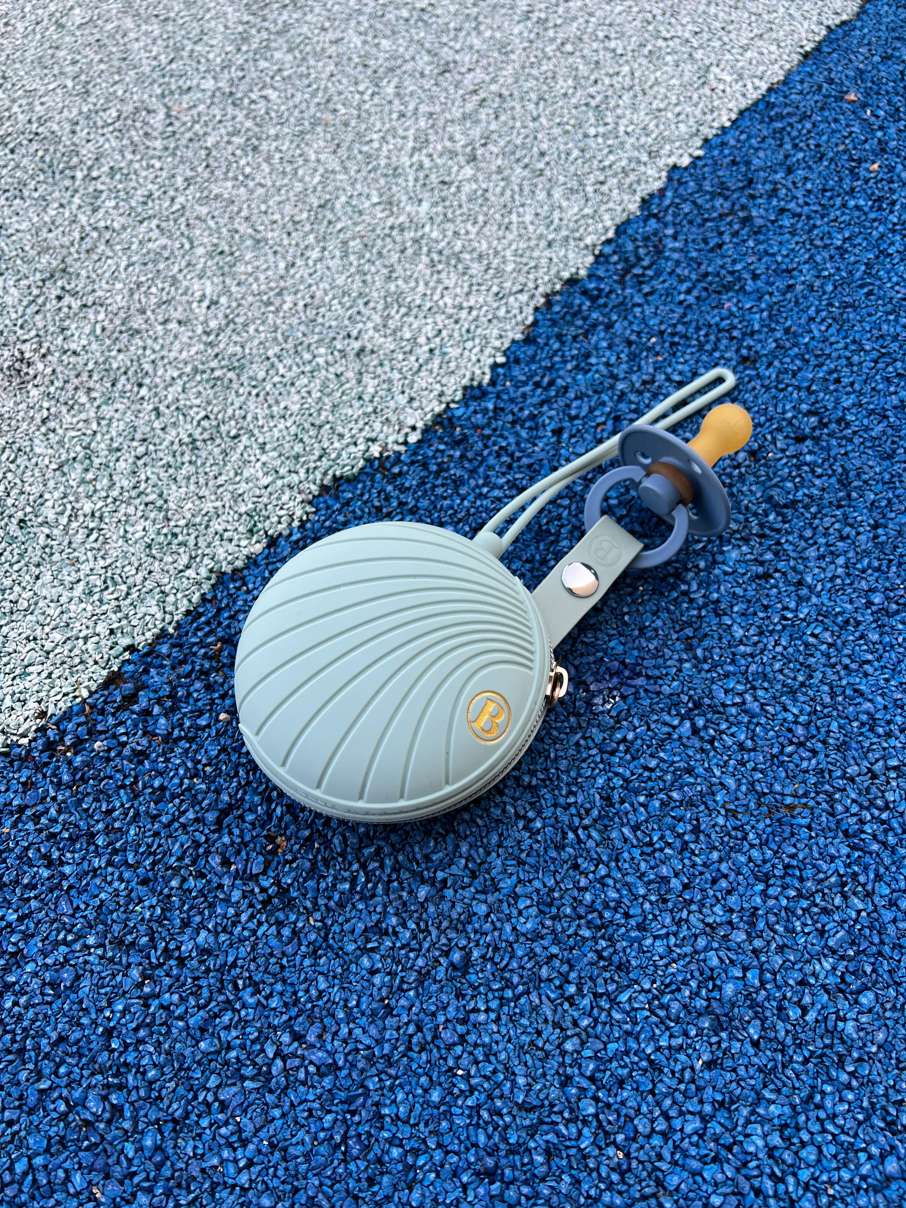 Boîte à tétine en silicone Vert de Bim Bam Bloom, sans BPA ni Phtalates conçue pour protéger et transporter jusqu'à 4 tétines en toute sécurité. Son design élégant en fait un accessoire indispensable pour les parentts.