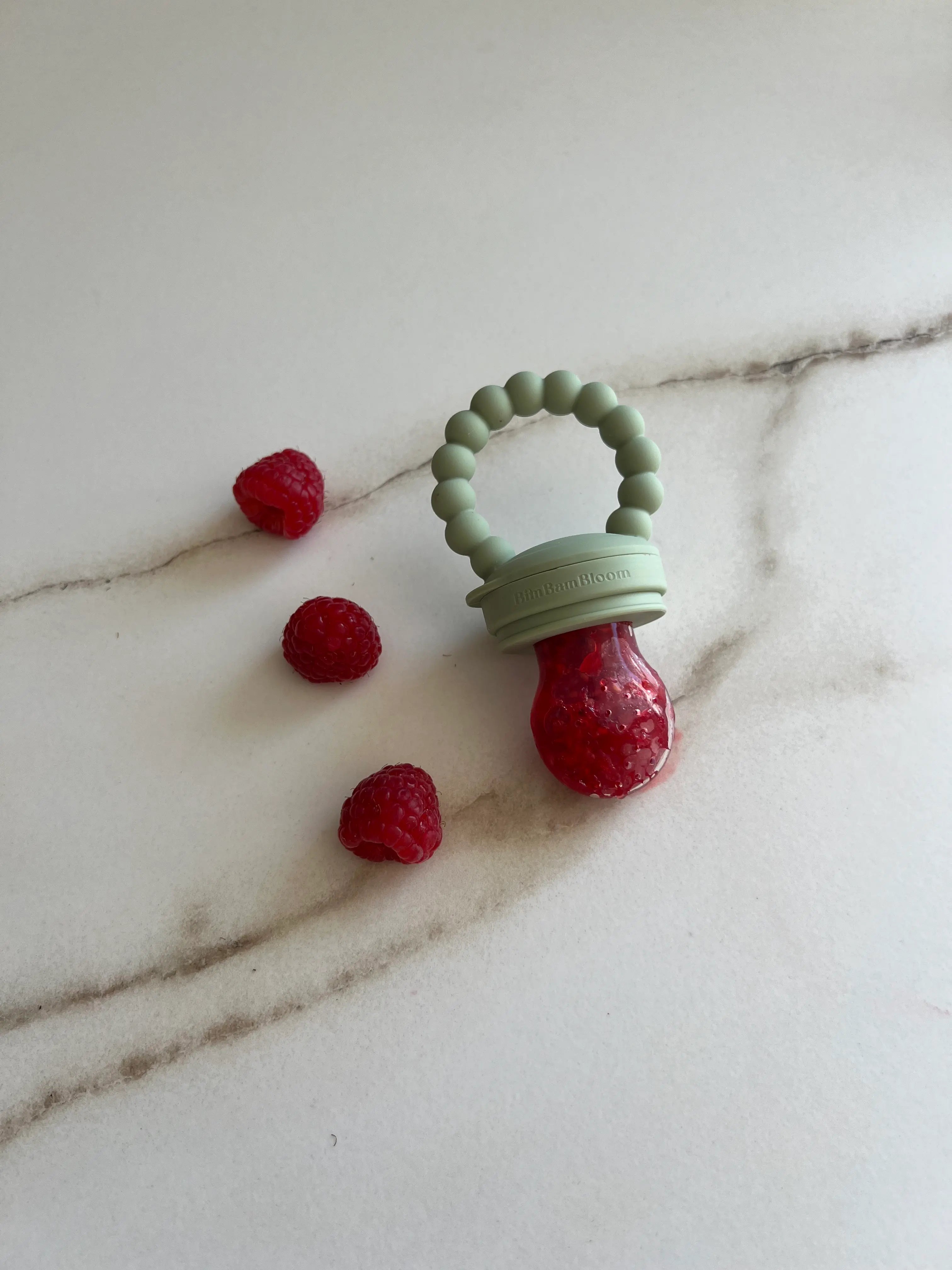 Cadeau de naissance original, pack tetine grignoteuse, tetine a fruit, gourmande Yummy Tot vert Bim Bam Bloom avec des frambises bien fraiches et juteuses.