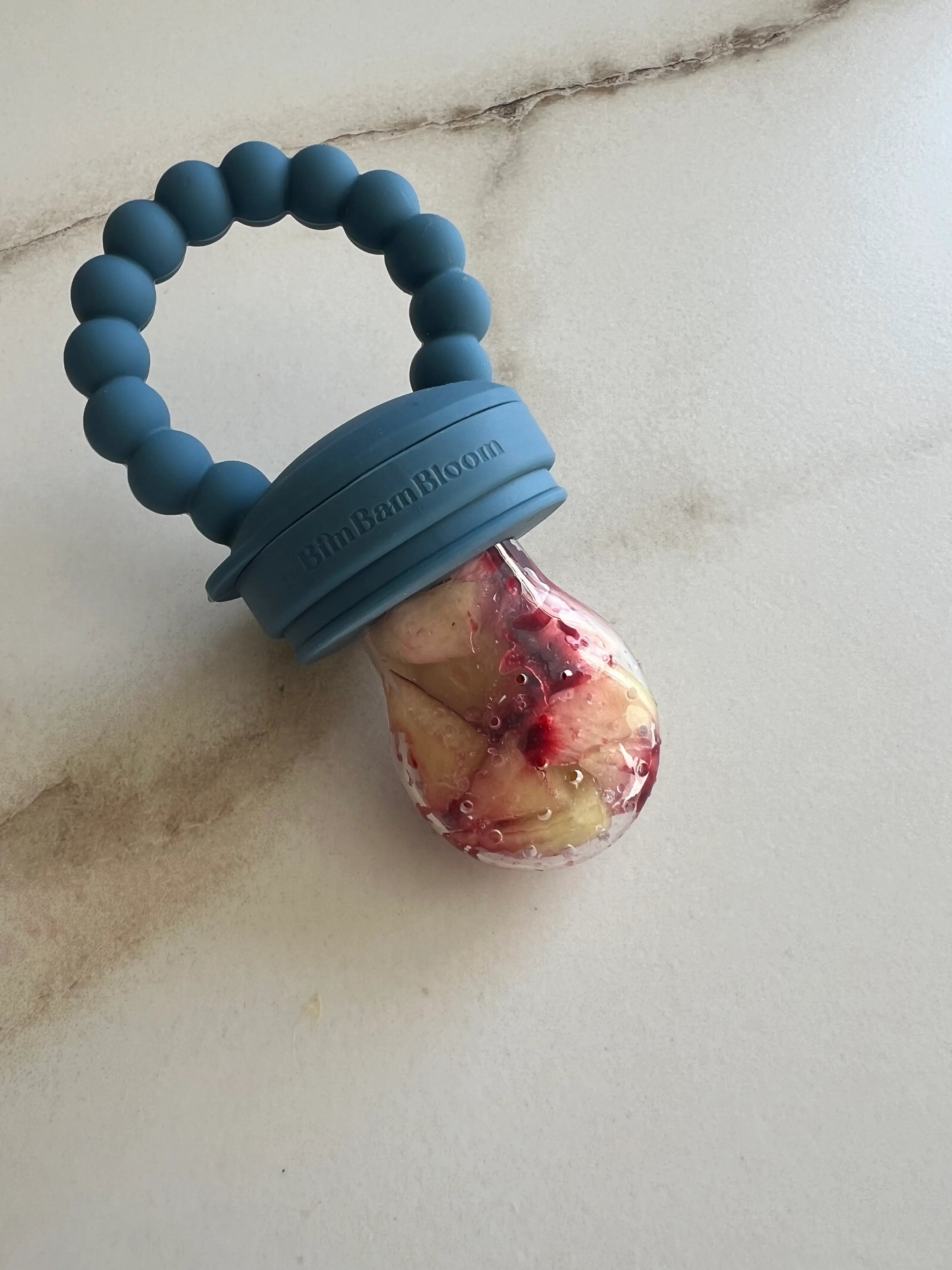 Tetine grignoteuse en silicone bleu. Tetine a fruit Bim Bam Bloom. Tetine remplie de nectarine.