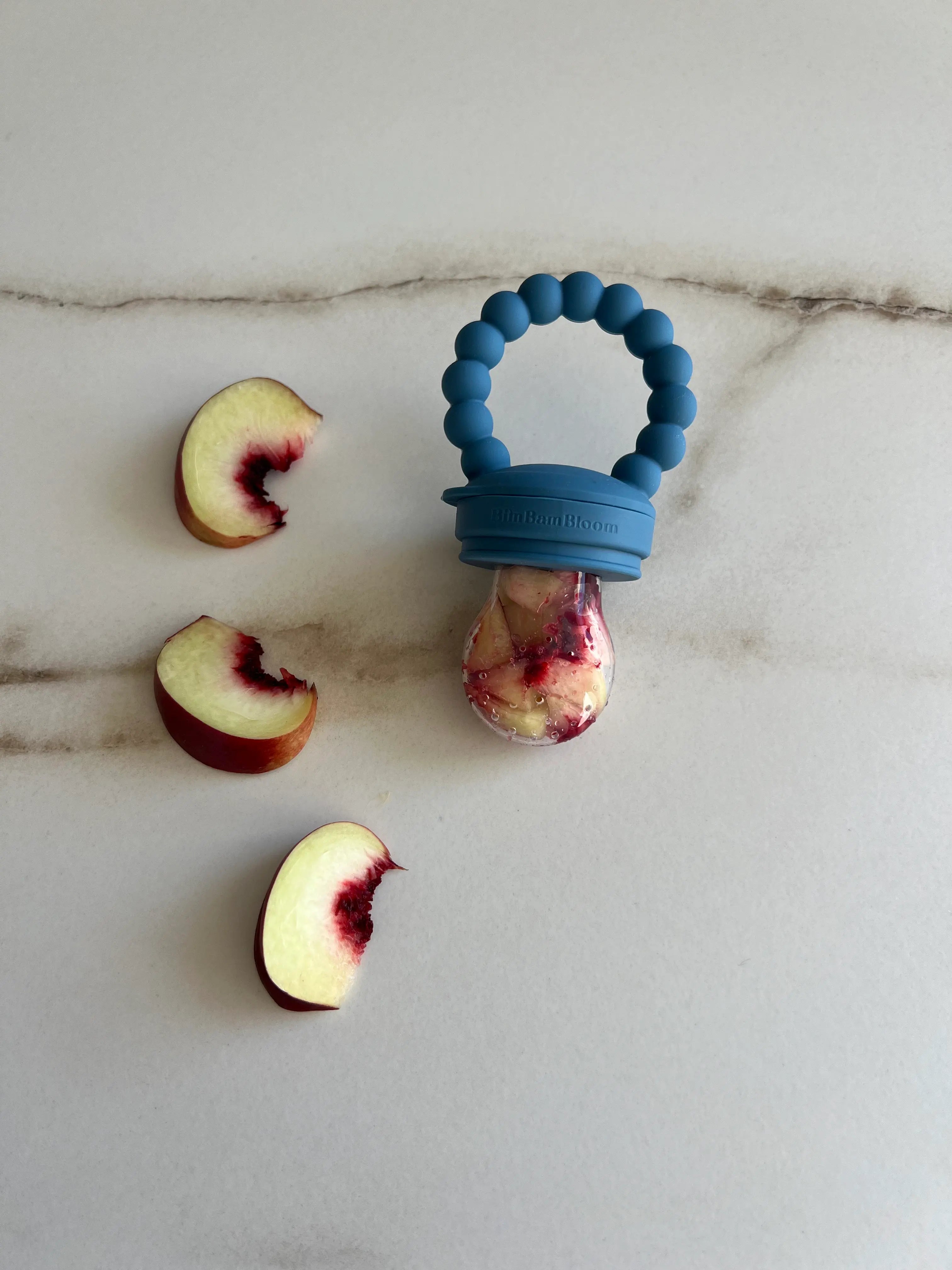 Tetine grignoteuse en silicone Bleu Bim Bam Bloom. Fruit nectarine dans la tetine.