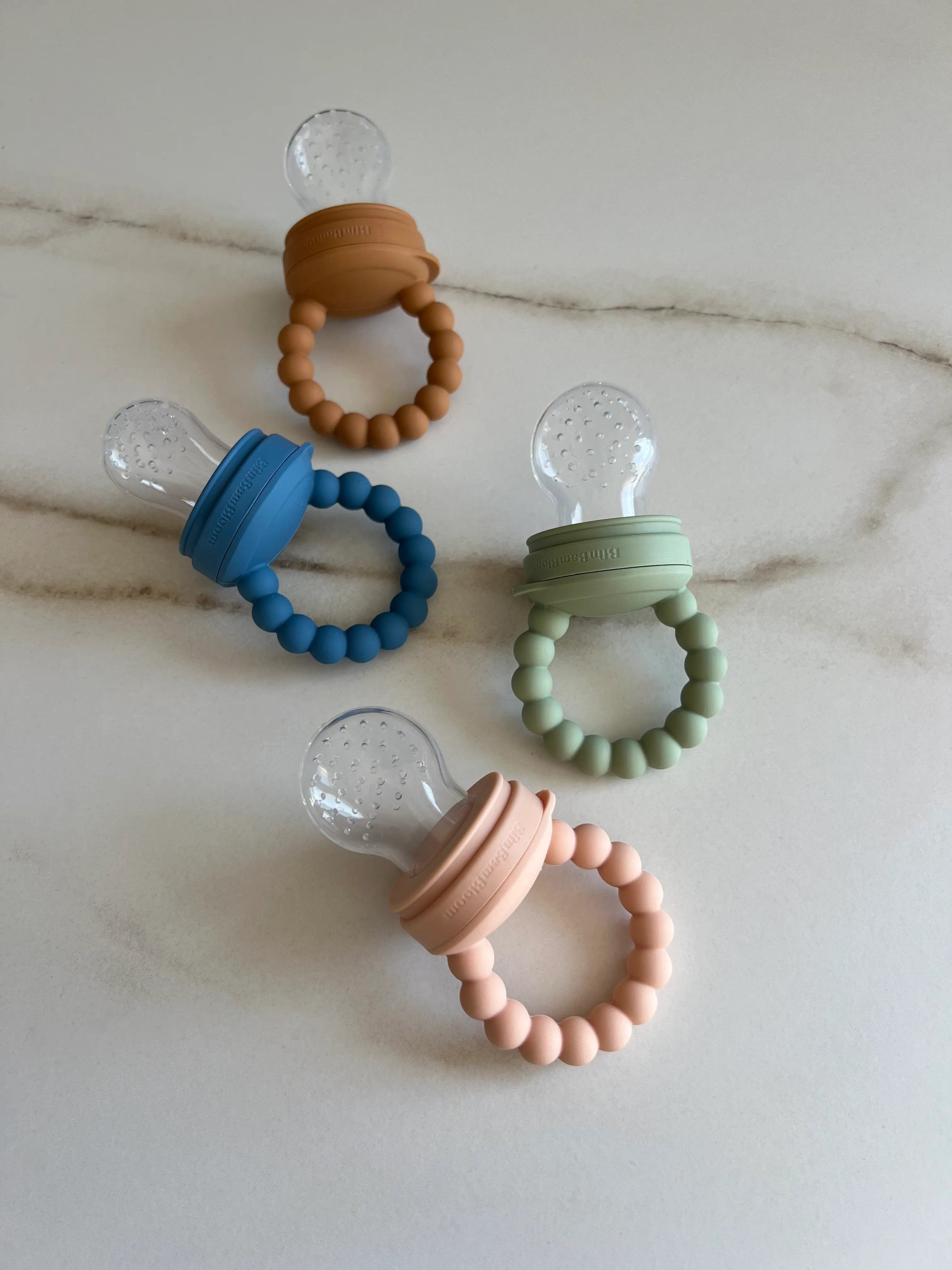 Tetne grignoteuse en silicone Bim Bam Bloom. tetine a fruit pour bebe. Nos 4 couleurs ensemble, Bleu, vert, rose et camel.
