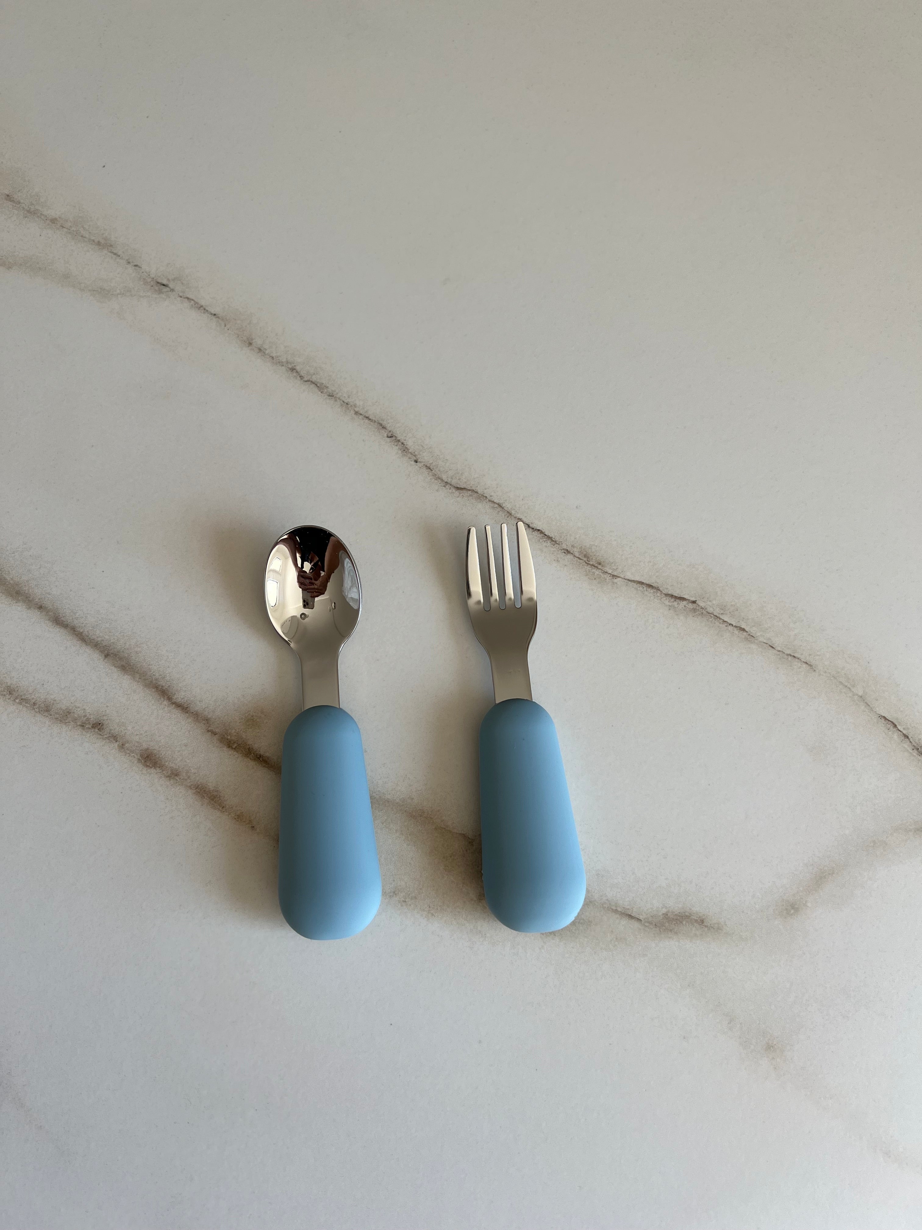 Couverts bébé bleu cuillère et fourchette en silicone et inox pour favoriser l’autonomie lors des repas